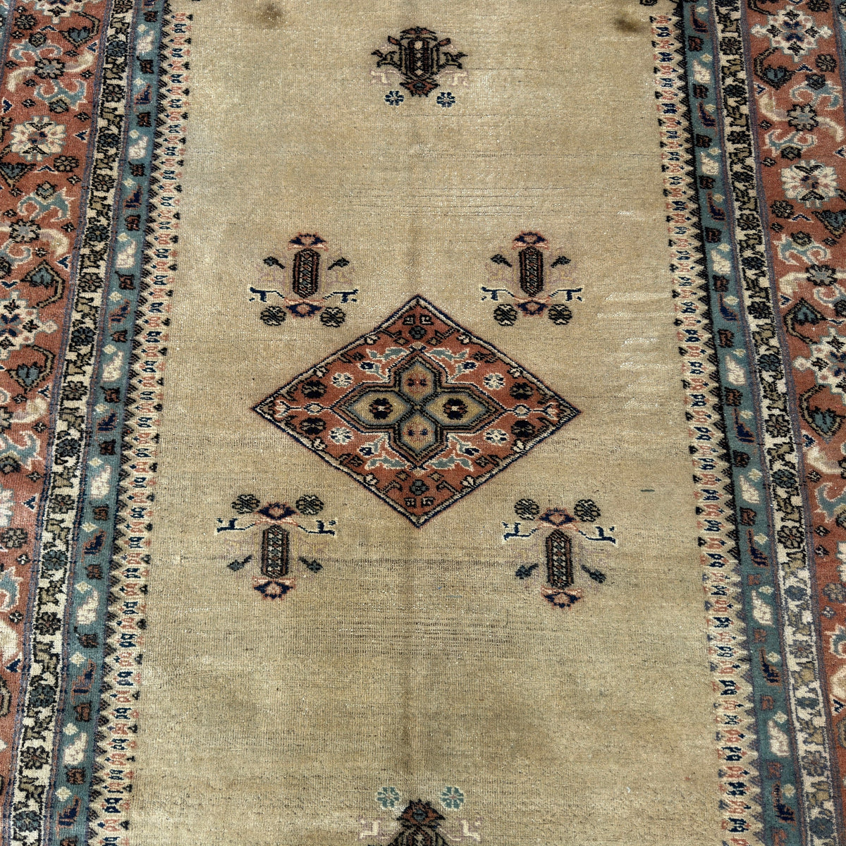 1970s beige turkish rug with geometric design, hand-knotted weave and low pile.