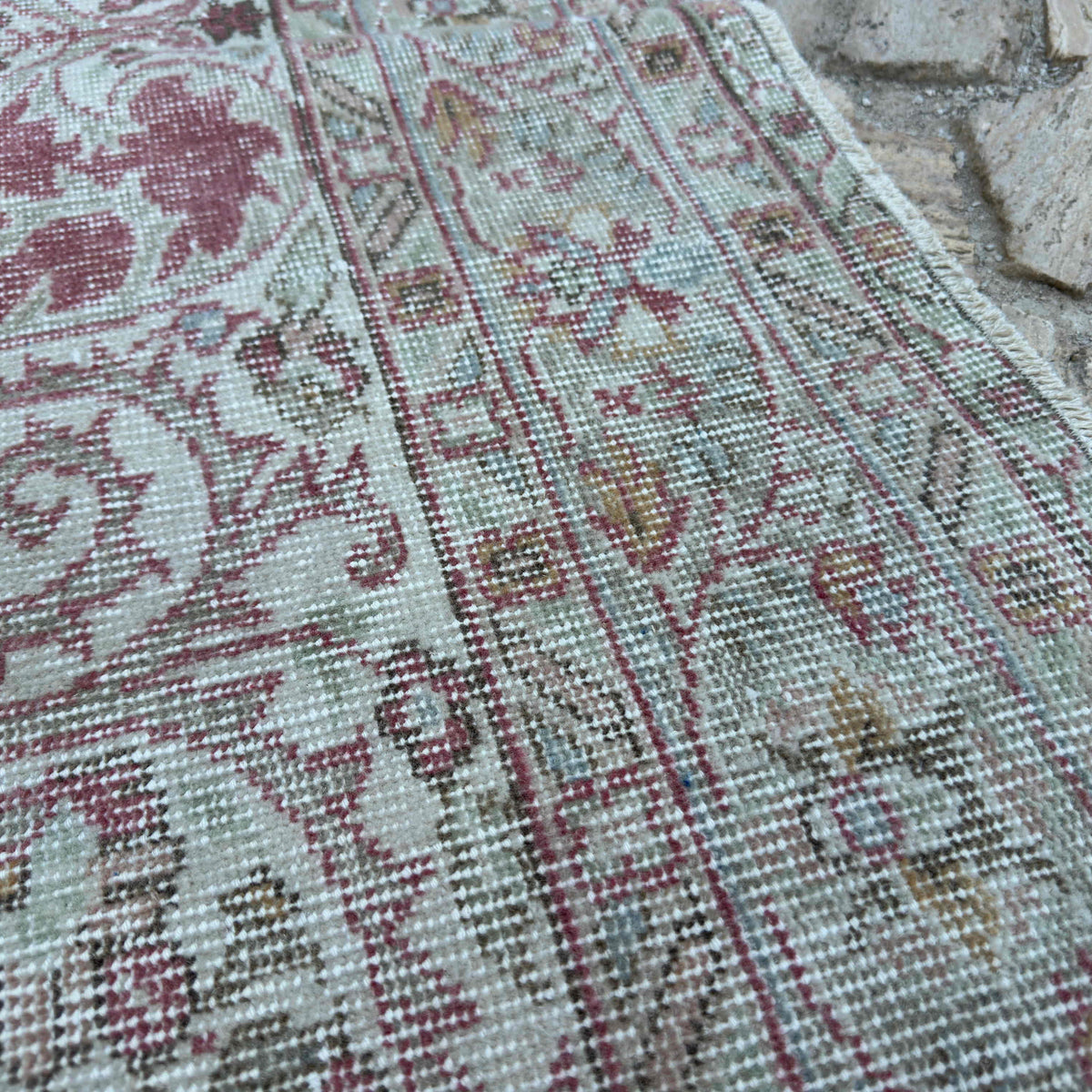 Close-up of the red turkish rug showing medallion details, hand-knotted weave, wool and cotton and low pile.