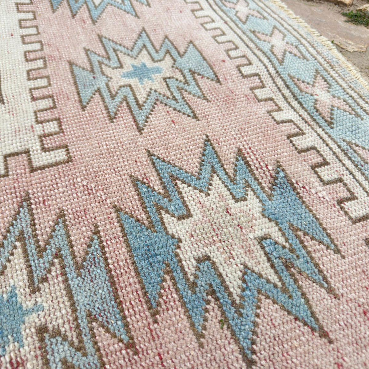 Close-up of the pink turkish rug showing traditional details, hand-knotted weave, wool and cotton and low pile.
