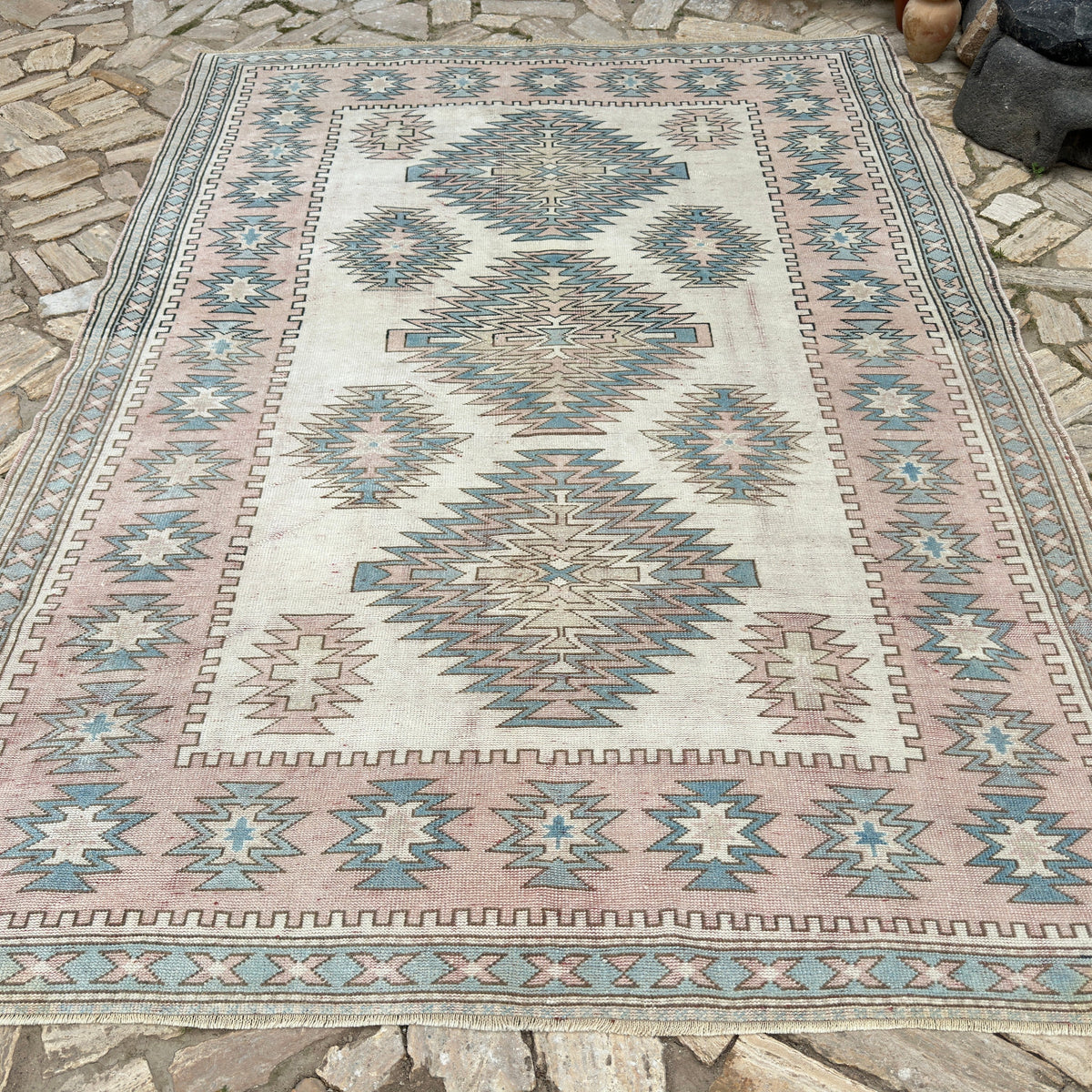 Pink 7' x 10' turkish rug in wool and cotton, shown on the floor.