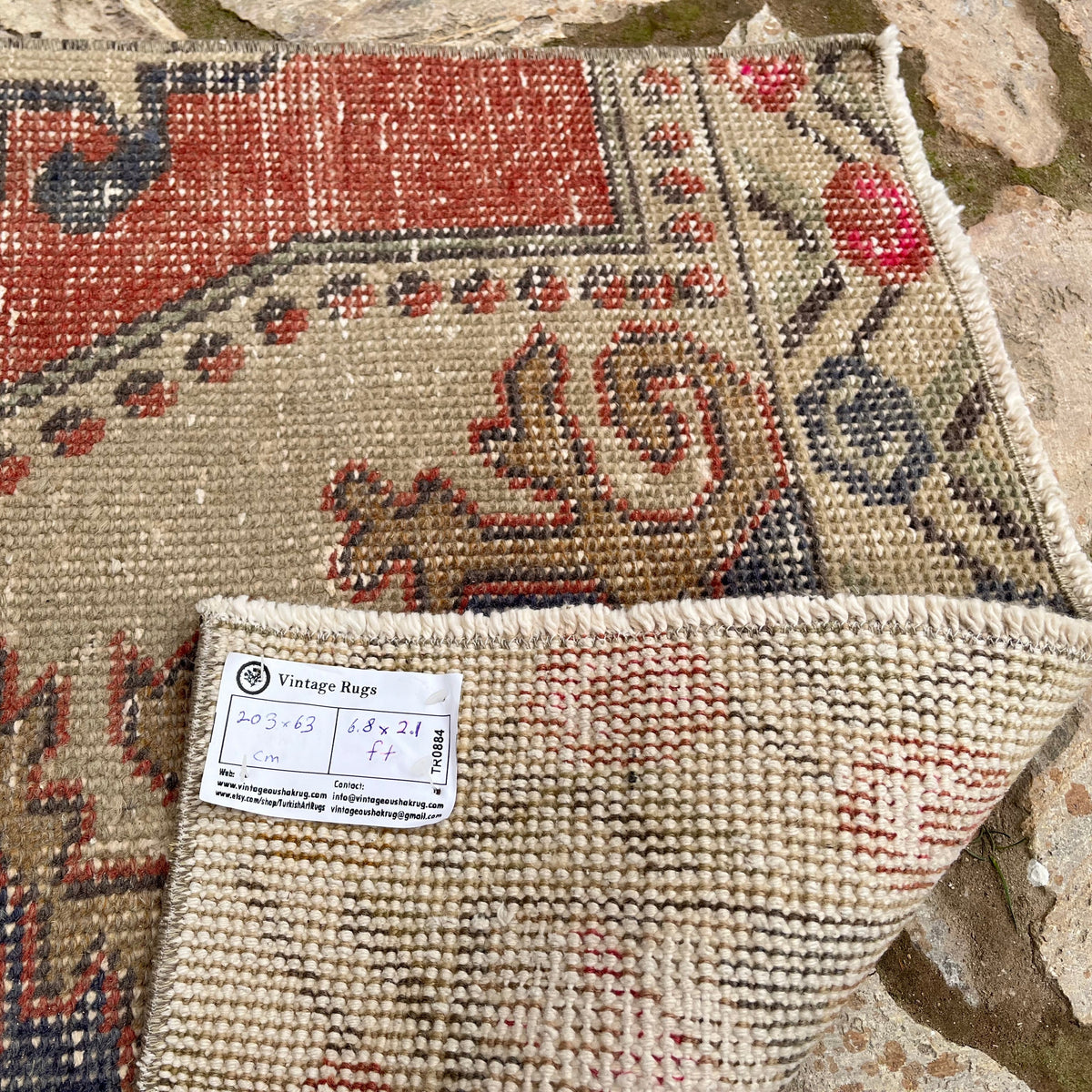 Close-up of the red turkish runner rug showing traditional details, hand-knotted weave, wool and cotton and low pile.