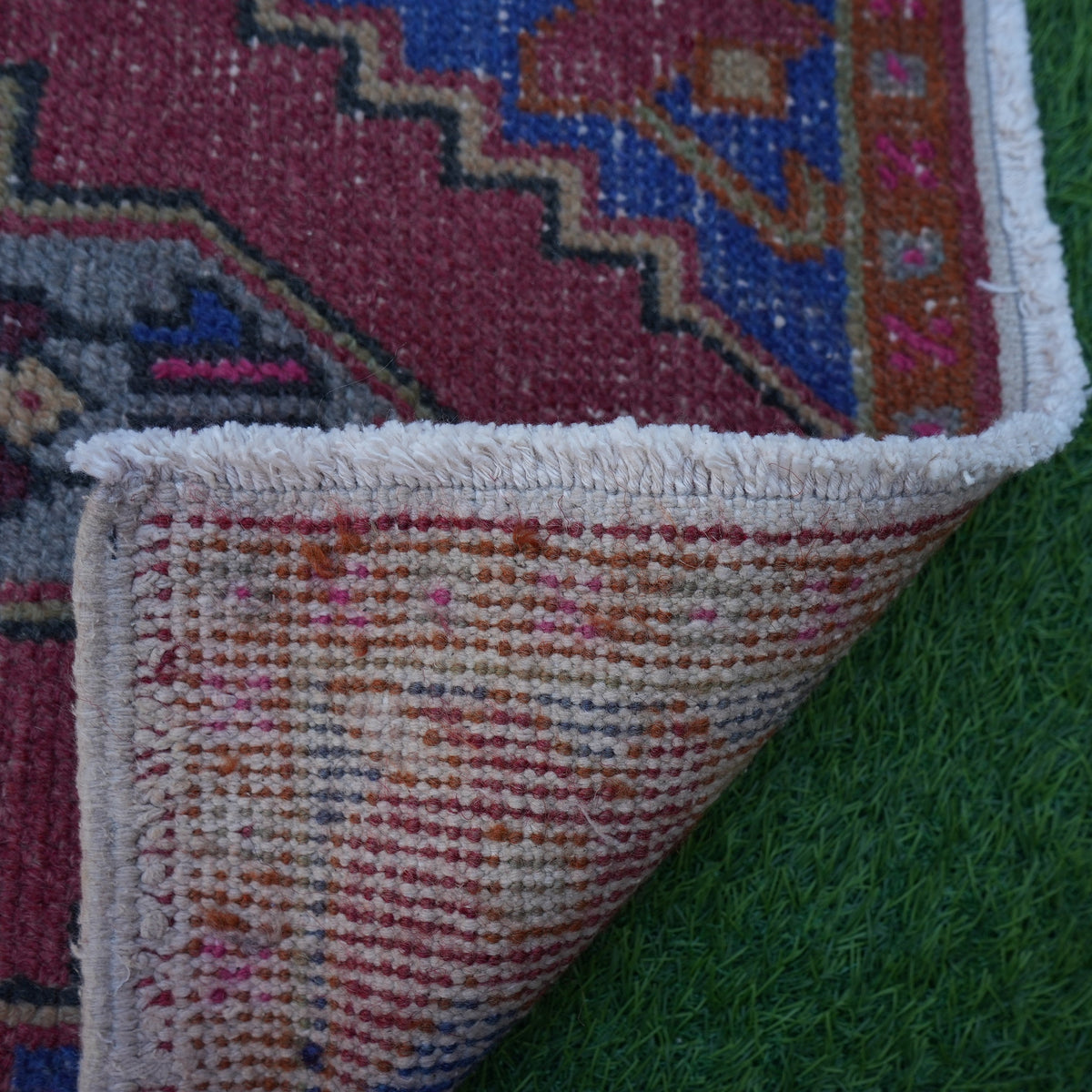 1970s red turkish small rug with geometric design, hand-knotted weave and low pile.