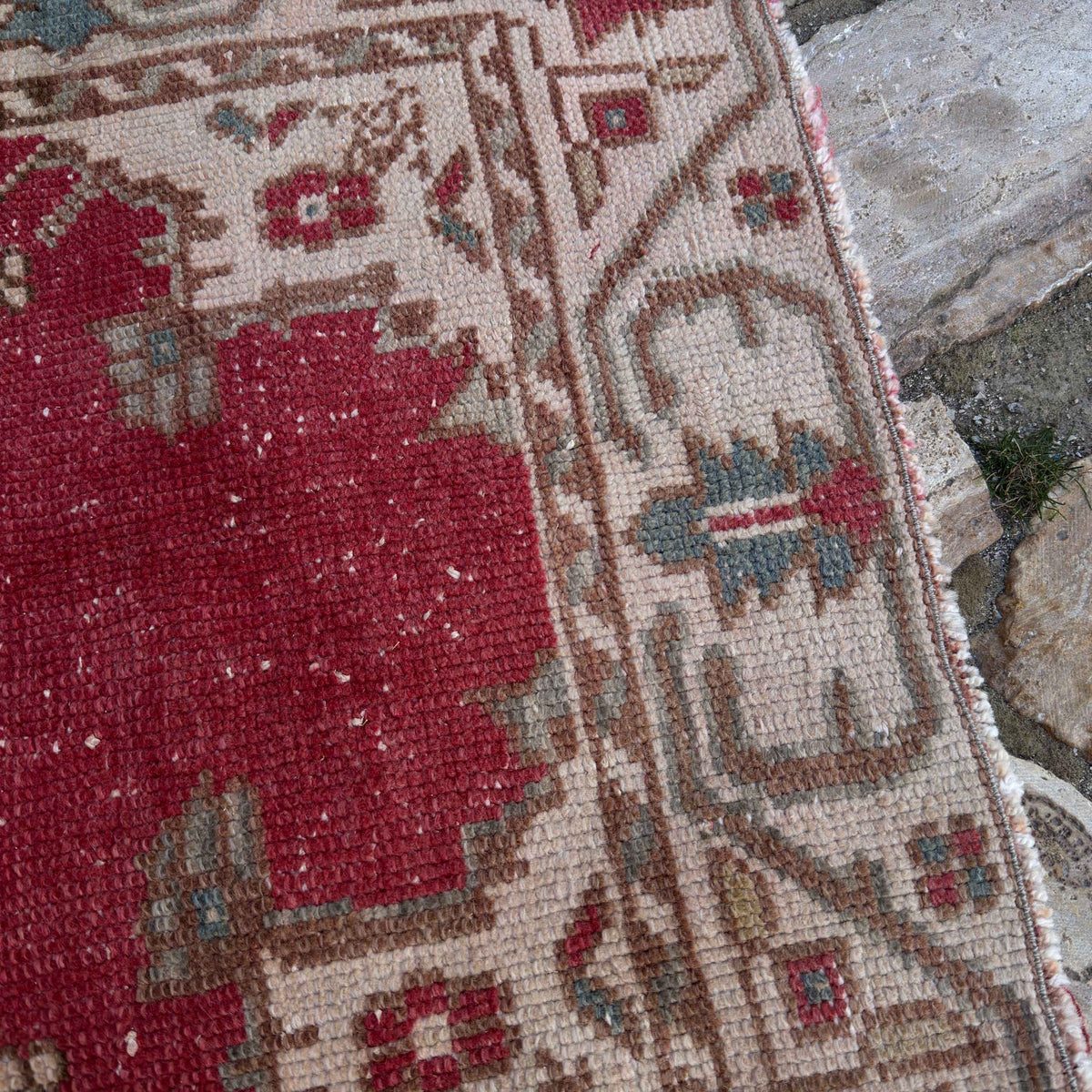 Close-up of the red vintage Turkish anatolian rug showing medallion details, hand-knotted weave, wool and cotton and low pile.