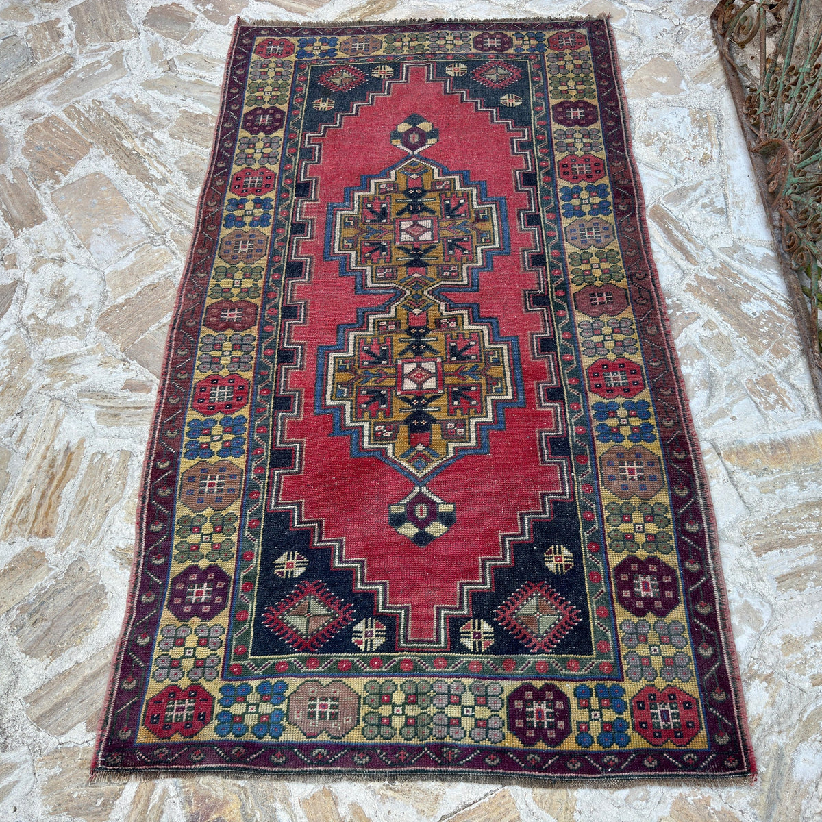 Red 4' x 7' vintage Turkish anatolian rug in wool and cotton, shown on the floor.