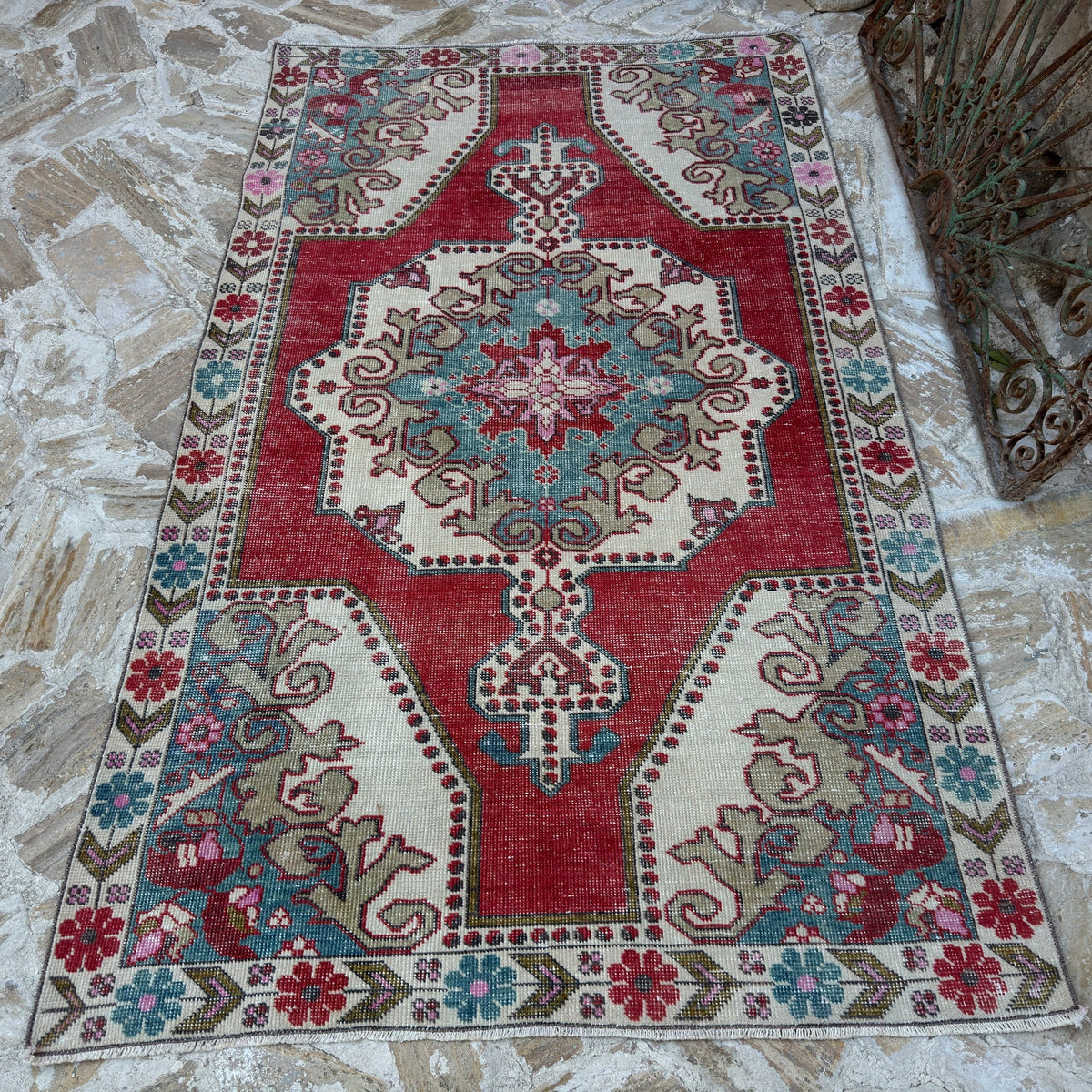Red 5' x 8' vintage Turkish anatolian rug in wool and cotton, shown on the floor.