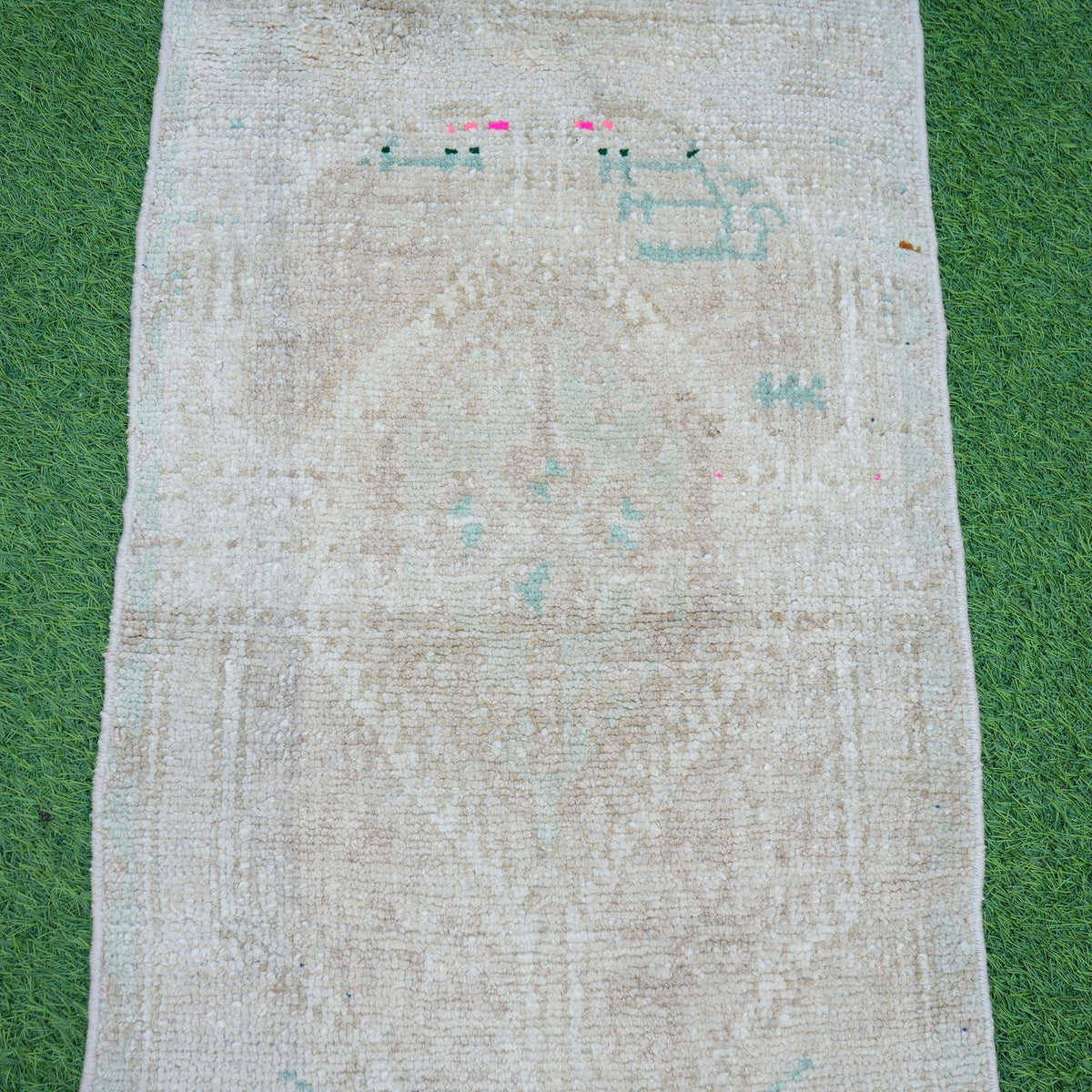 Close-up of the beige vintage Turkish area rug showing neutral details, hand-knotted weave, wool and cotton and low pile.