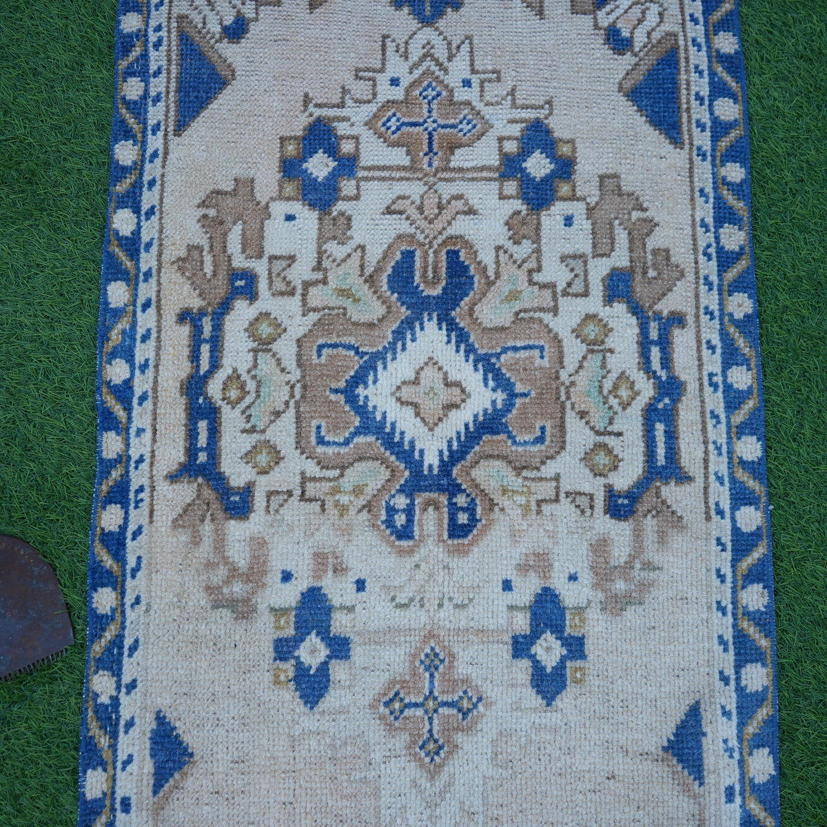 Close-up of the blue vintage Turkish area rug showing traditional details, hand-knotted weave, wool and cotton and low pile.