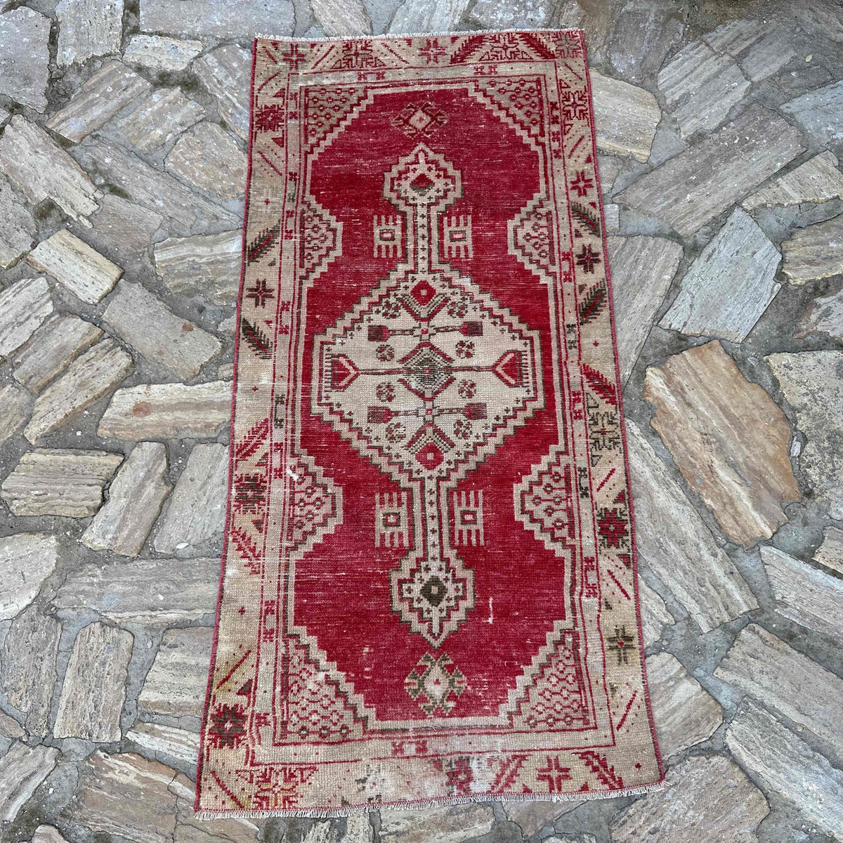Red 2' x 5' vintage Turkish area rug in wool and cotton, shown on the floor.