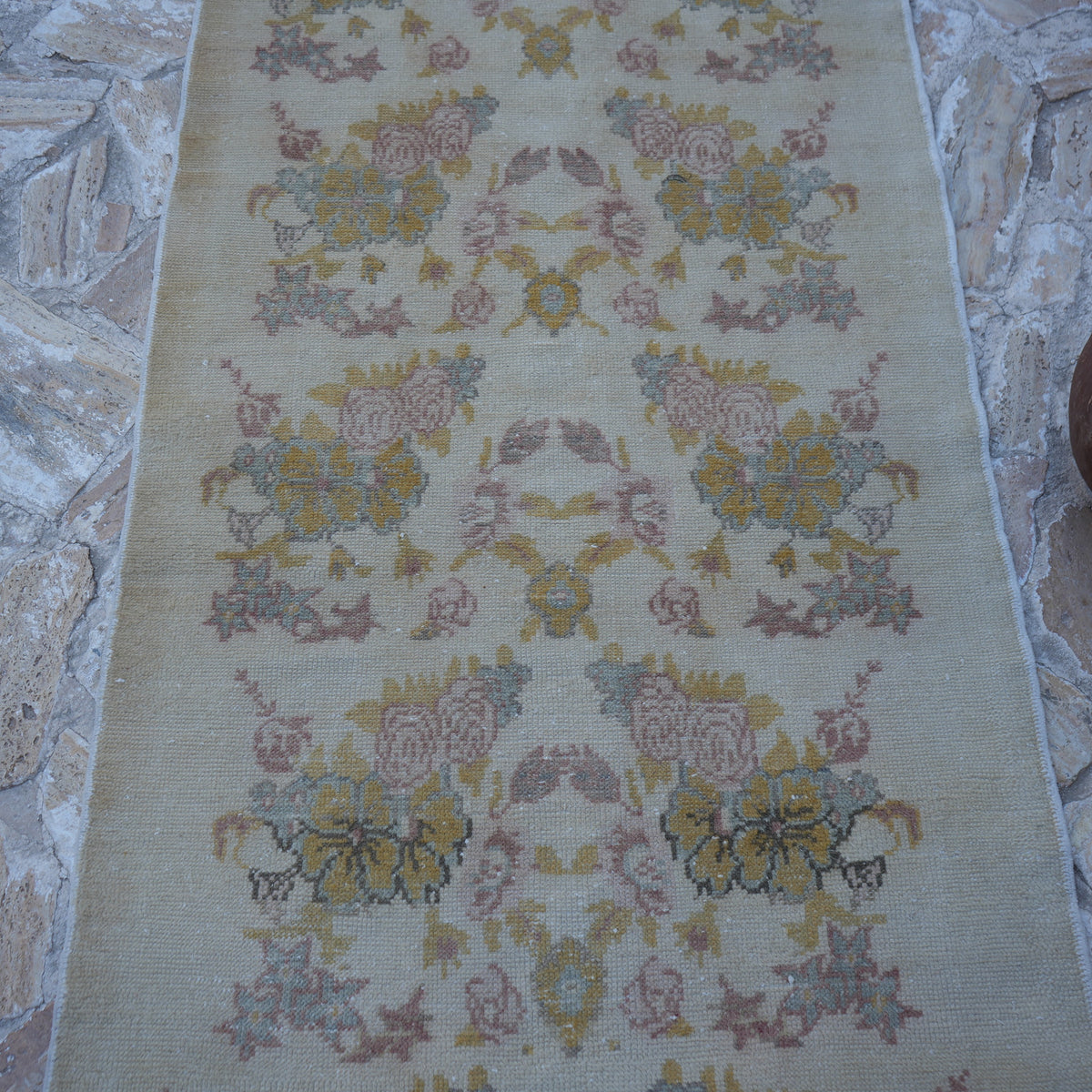 Close-up of the beige vintage Turkish area rug showing traditional details, hand-knotted weave, wool and cotton and low pile.