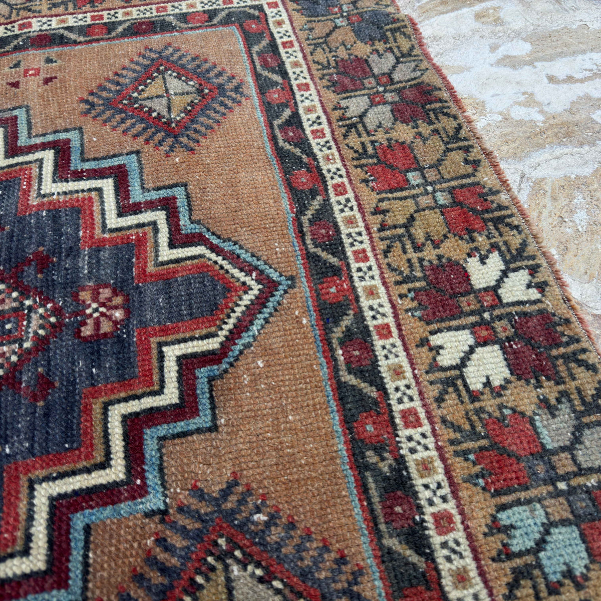 Close-up of the red vintage Turkish area rug showing traditional details, hand-knotted weave, wool and cotton and low pile.