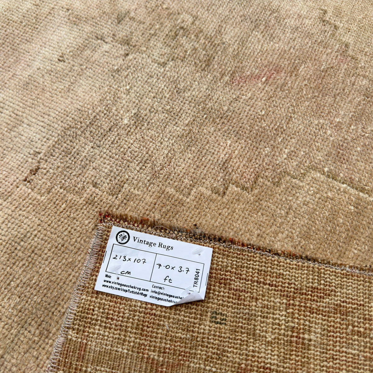 Close-up of the brown vintage Turkish area rug showing neutral details, hand-knotted weave, wool and cotton and low pile.