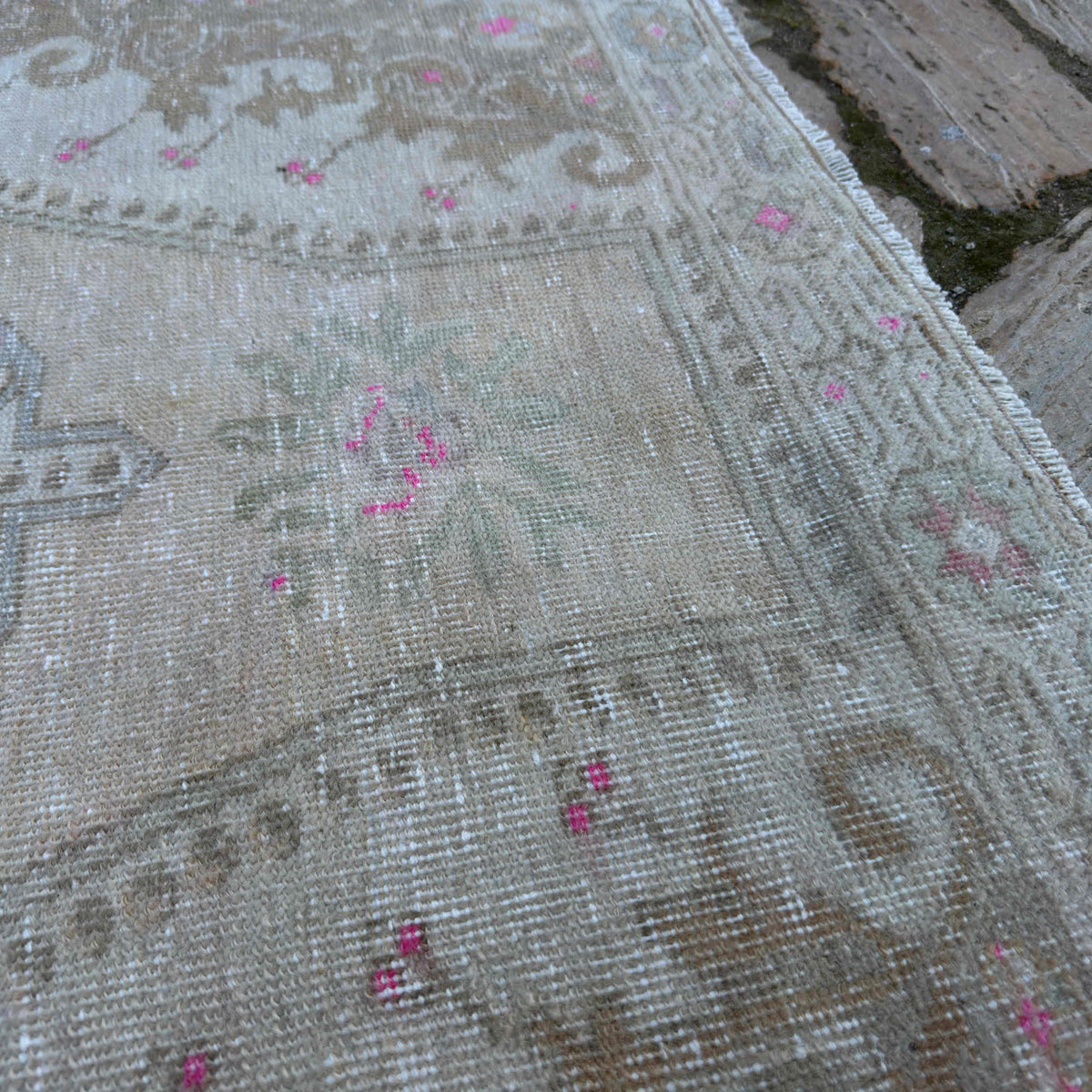 Close-up of the pale yellow vintage Turkish area rug showing neutral details, hand-knotted weave, wool and cotton and low pile.