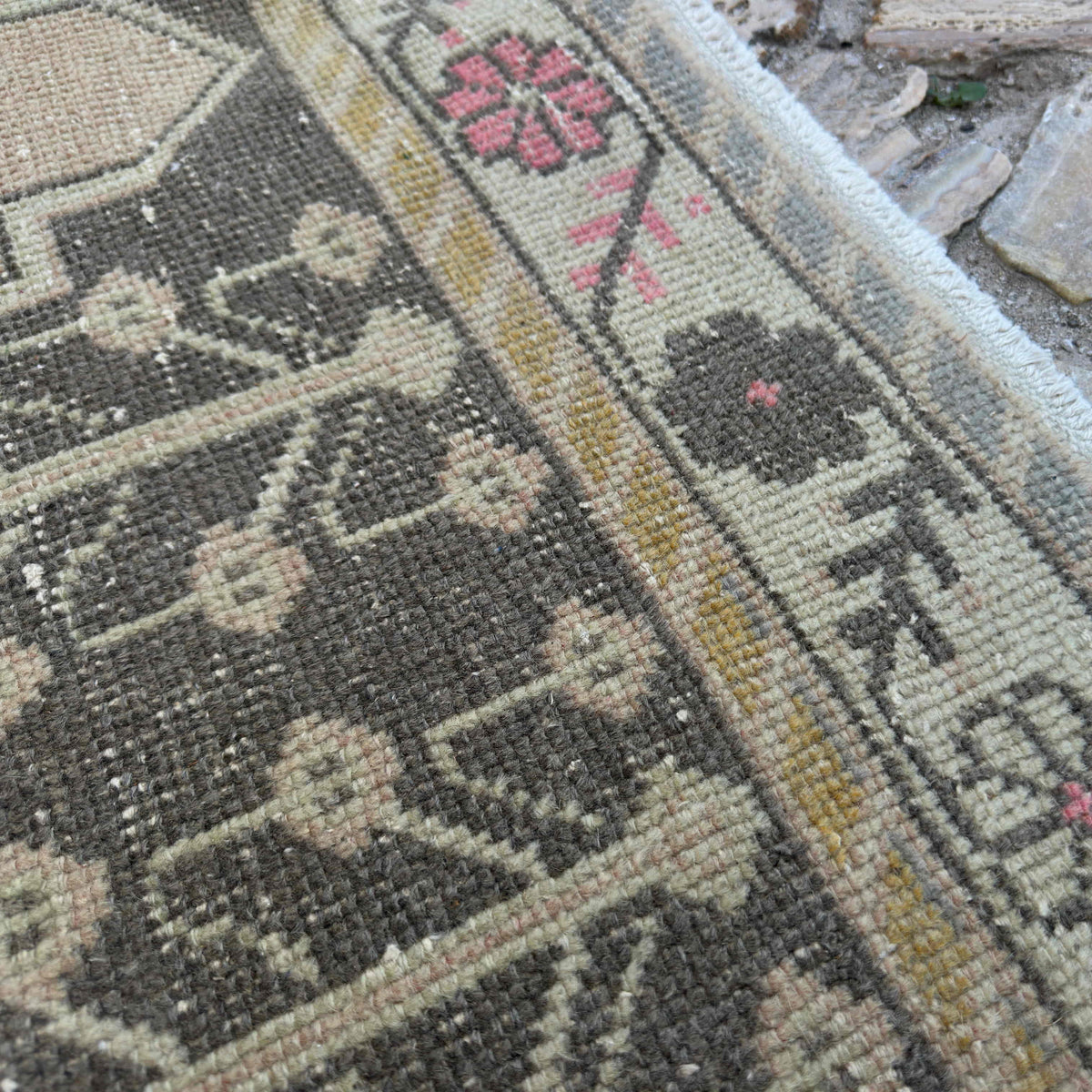 Close-up of the pink vintage Turkish area rug showing traditional details, hand-knotted weave, wool and cotton and low pile.