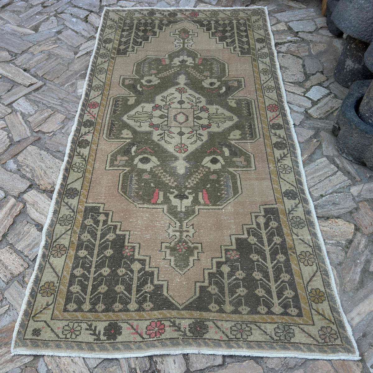 Pink 5' x 9' vintage Turkish area rug in wool and cotton, shown on the floor.