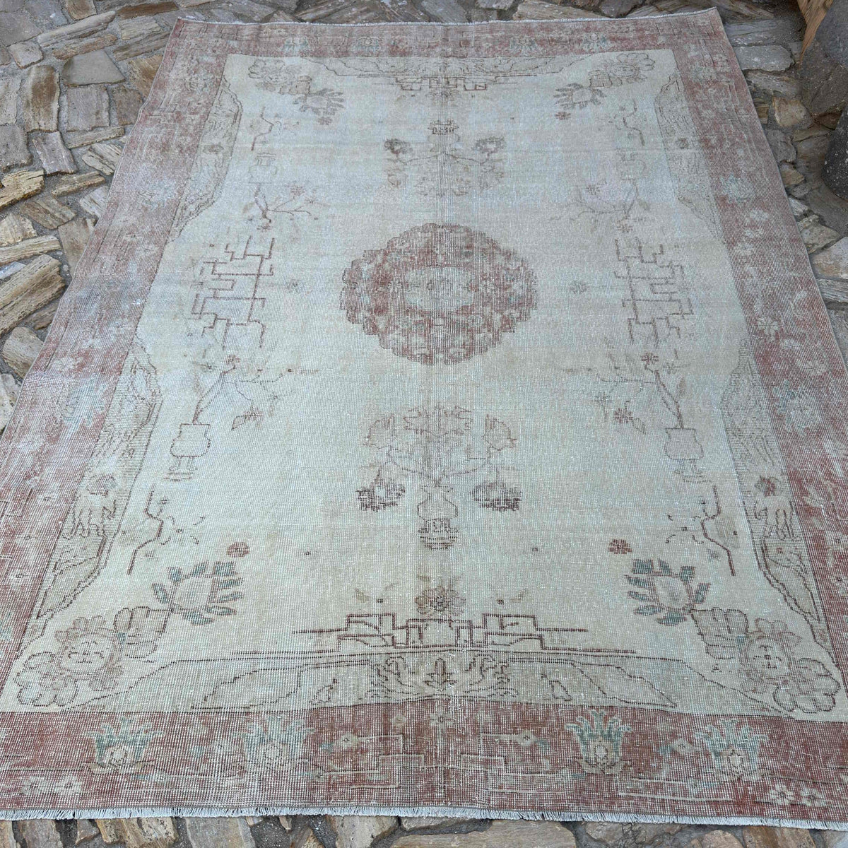 Pale Red 7' x 9' vintage Turkish area rug in wool and cotton, shown on the floor.