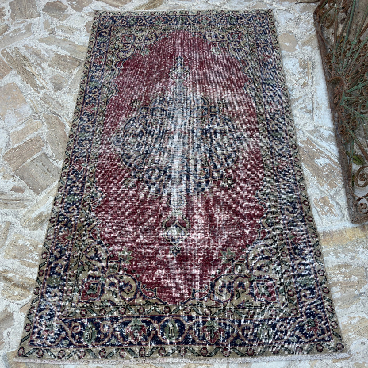 Red 4' x 7' vintage Turkish decorative rug in wool and cotton, shown on the floor.