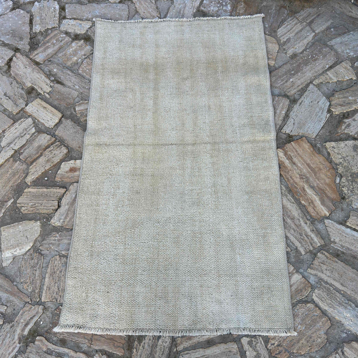 Beige 3' x 5' vintage Turkish distressed rug in wool and cotton, shown on the floor.