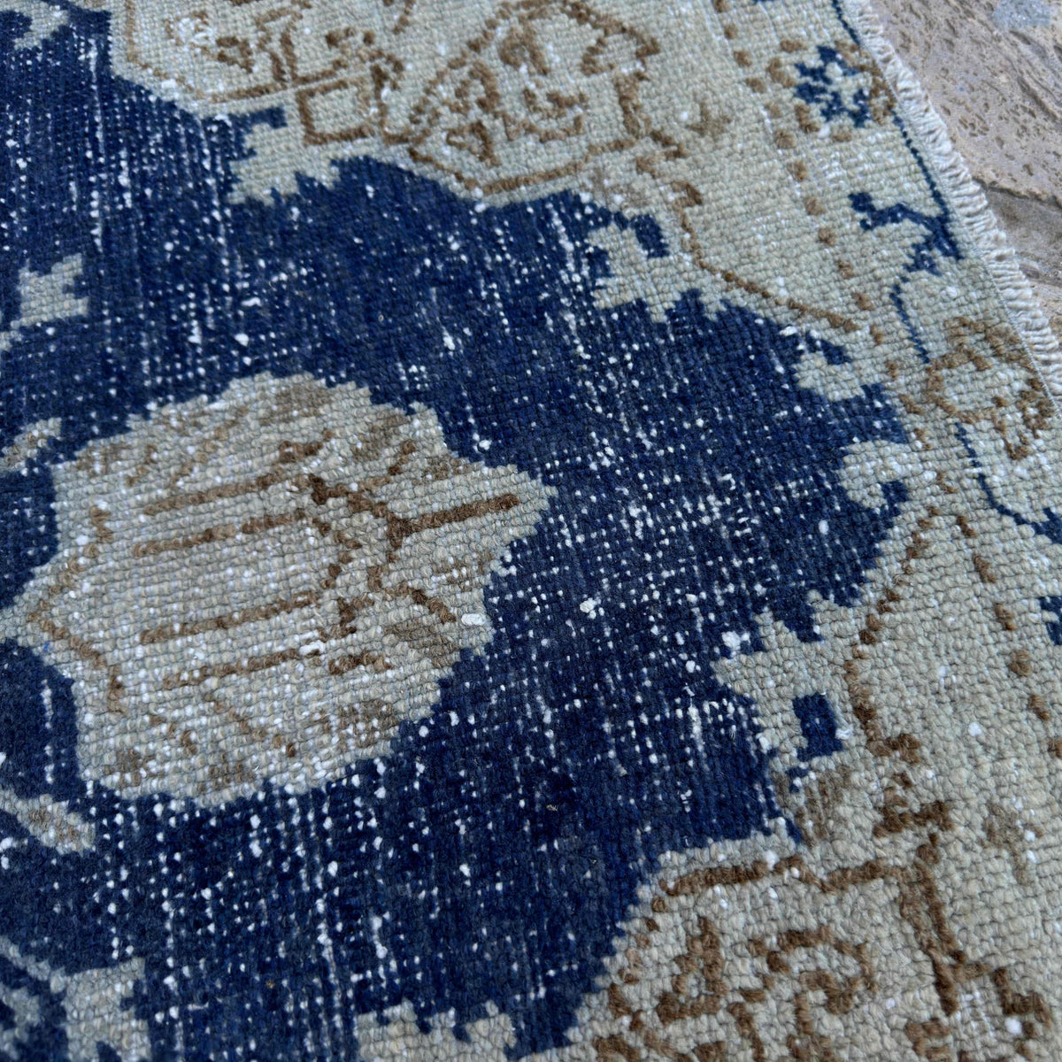 Close-up of the blue vintage Turkish distressed rug showing traditional details, hand-knotted weave, wool and cotton and low pile.