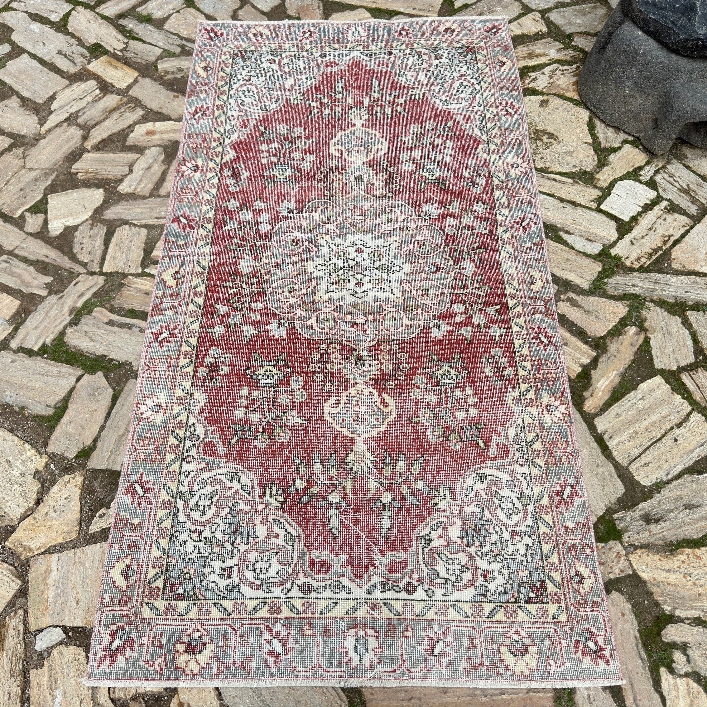 Red 3' x 7' vintage Turkish distressed rug in wool and cotton, shown on the floor.