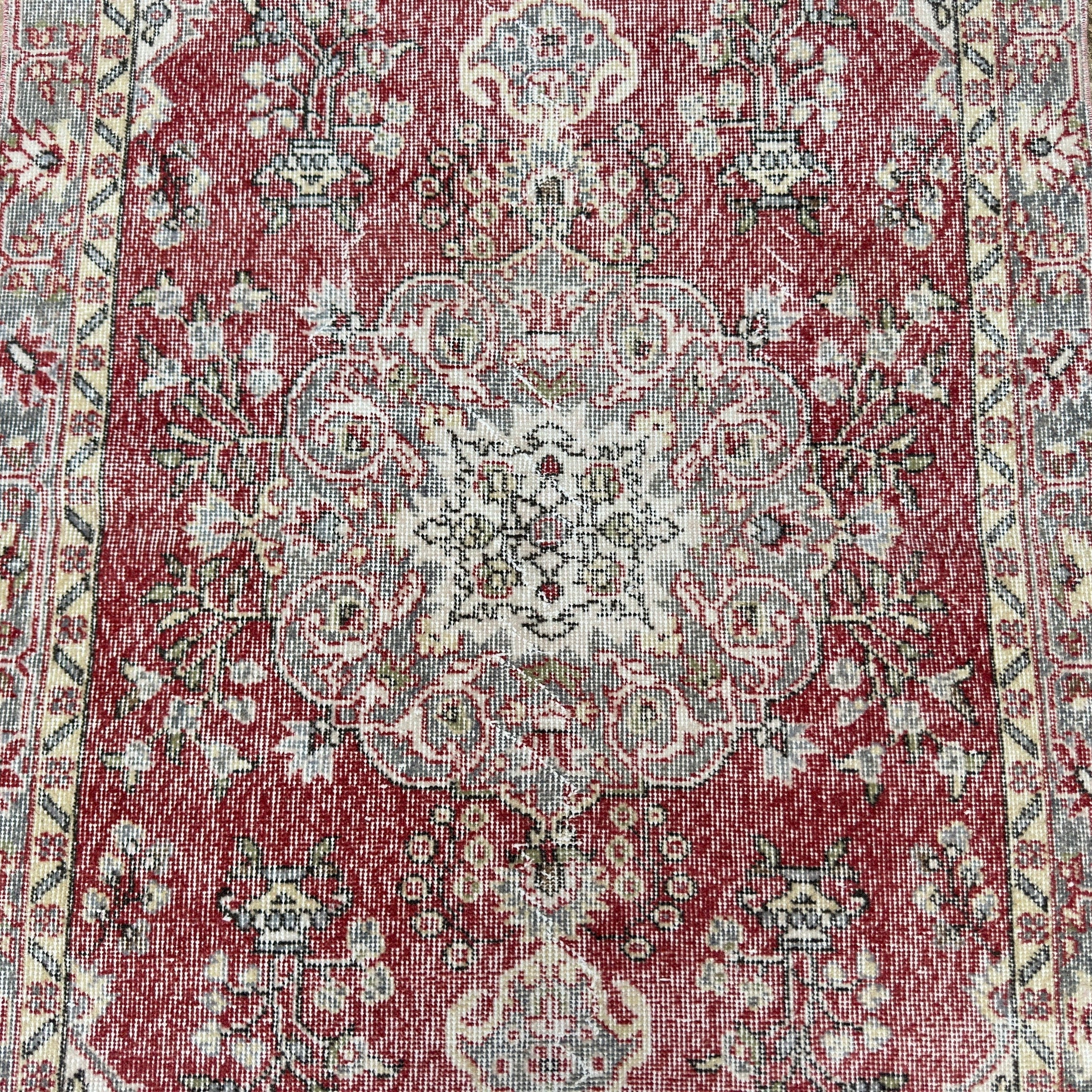 1970s red vintage Turkish distressed rug with medallion design, hand-knotted weave and low pile.