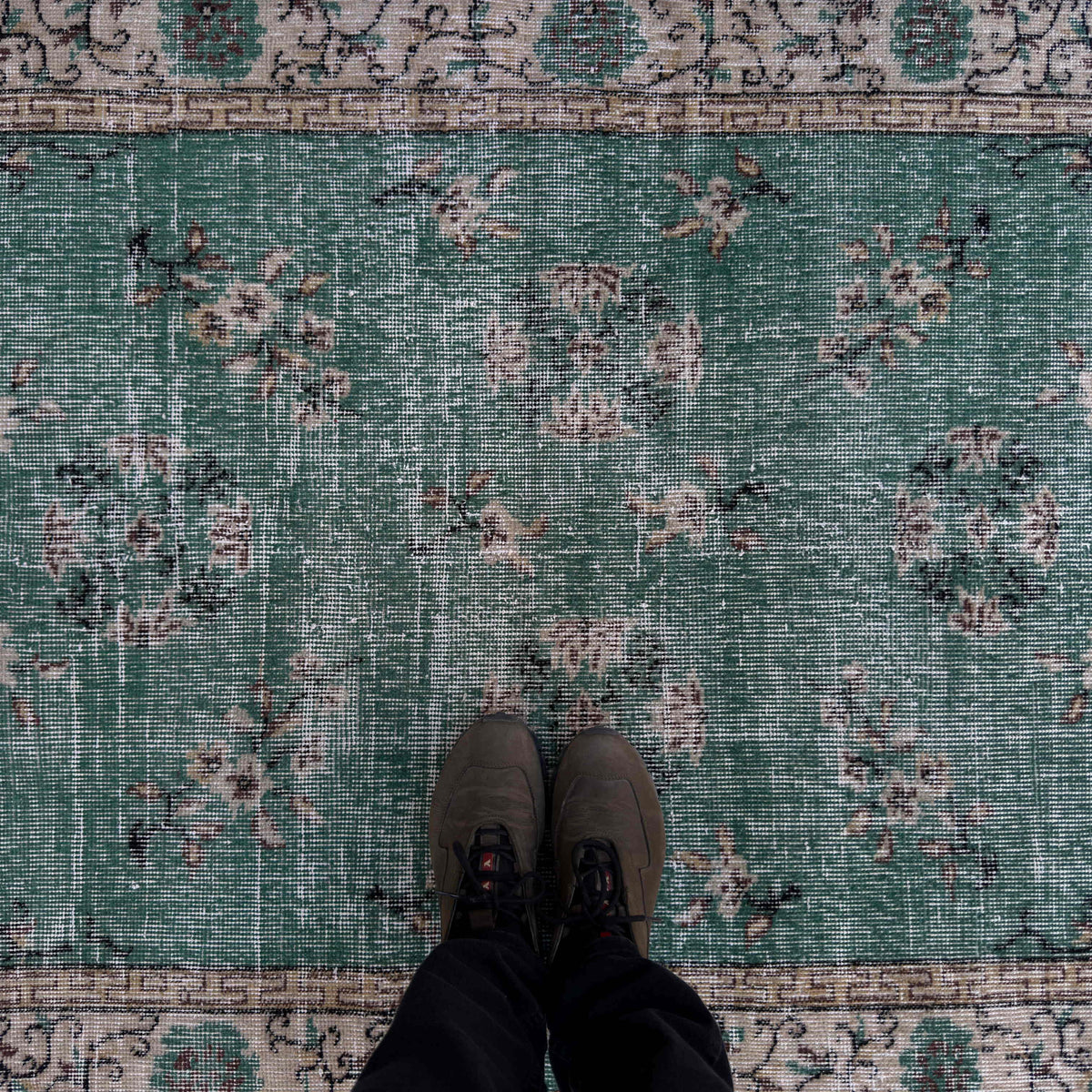 1970s green vintage Turkish distressed rug with traditional design, hand-knotted weave and low pile.