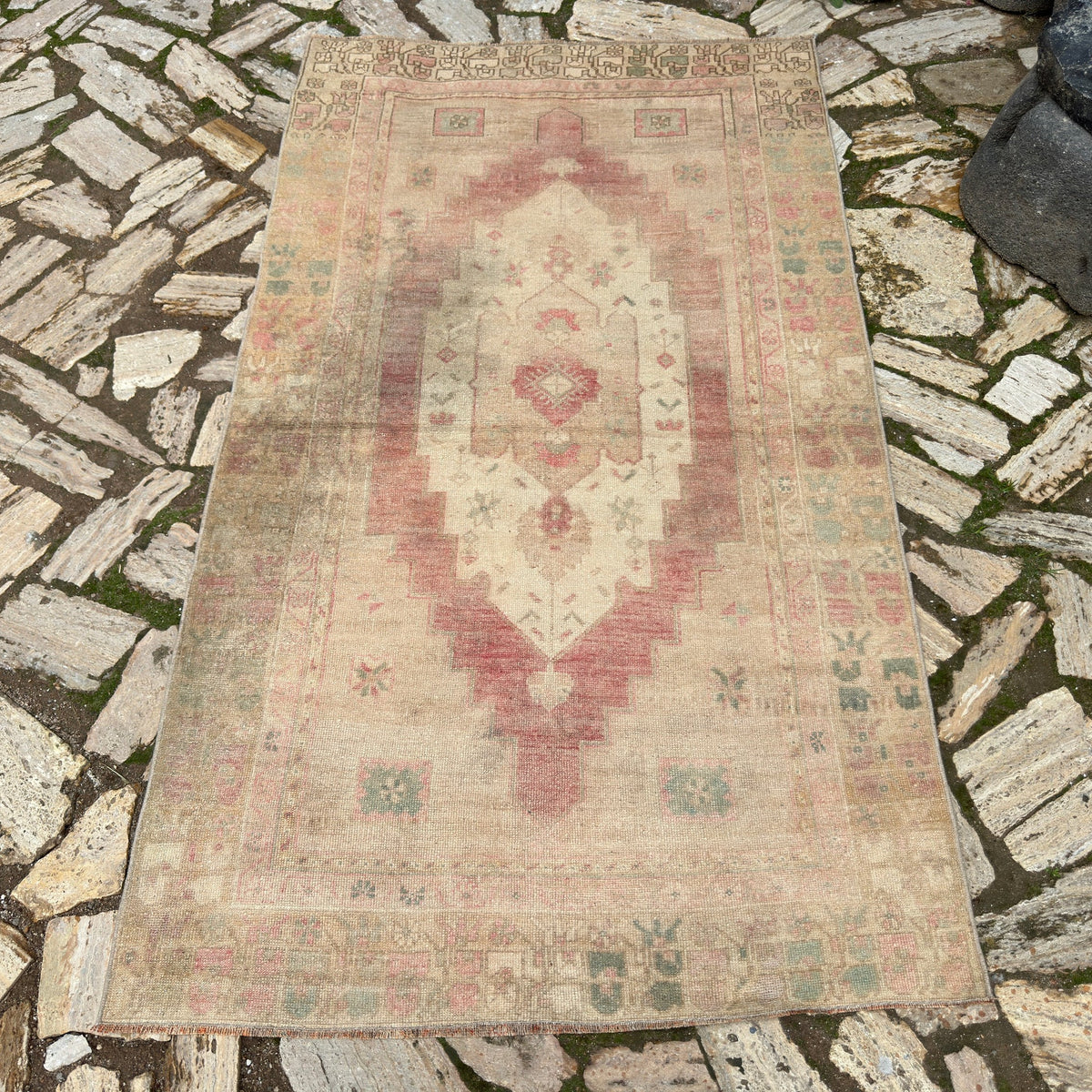 Beige 4' x 7' vintage Turkish distressed rug in wool and cotton, shown on the floor.