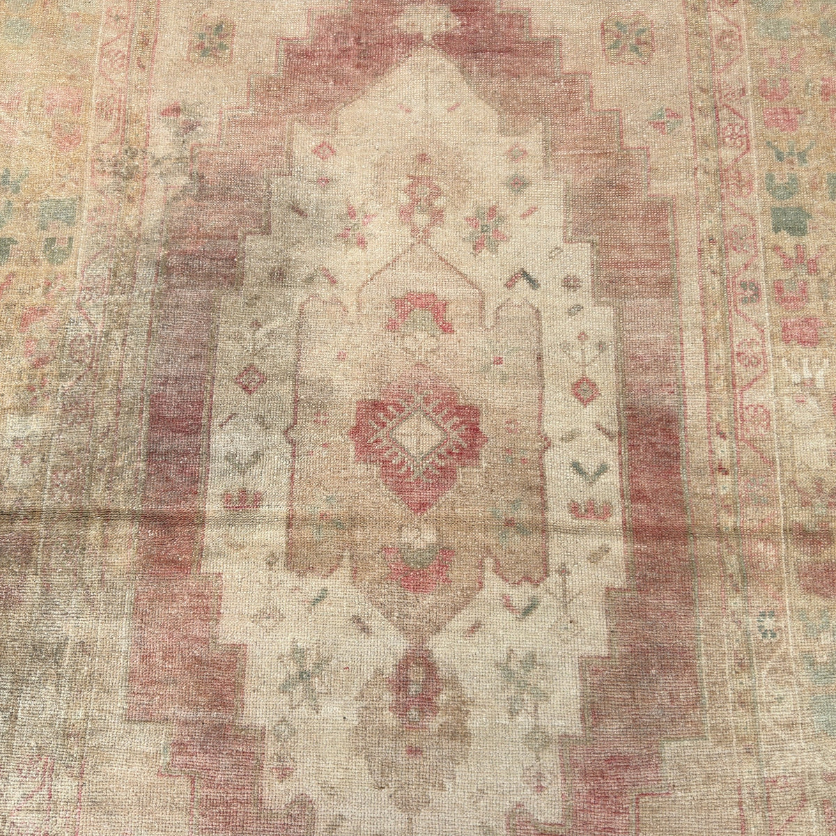 1970s beige vintage Turkish distressed rug with medallion design, hand-knotted weave and low pile.