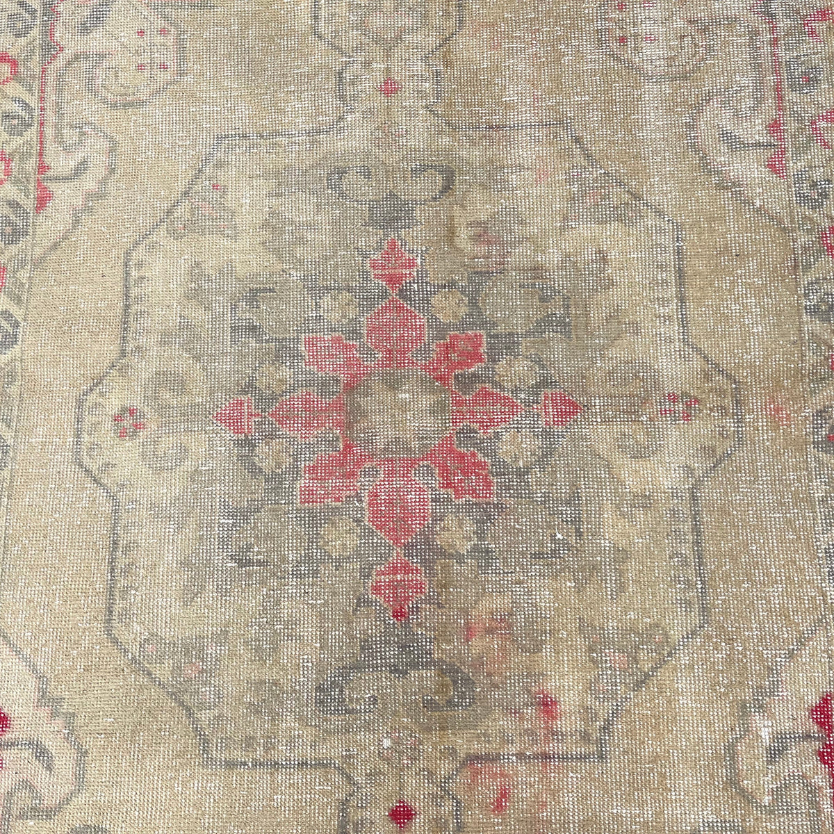 1970s beige vintage Turkish distressed rug with neutral design, hand-knotted weave and low pile.
