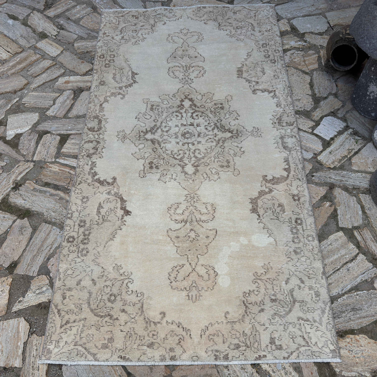 Beige 4' x 7' vintage Turkish distressed rug in wool and cotton, shown on the floor.
