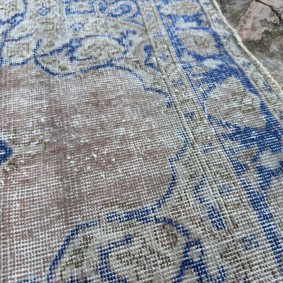 Close-up of the blue vintage Turkish distressed rug showing geometric details, hand-knotted weave, wool and cotton and low pile.