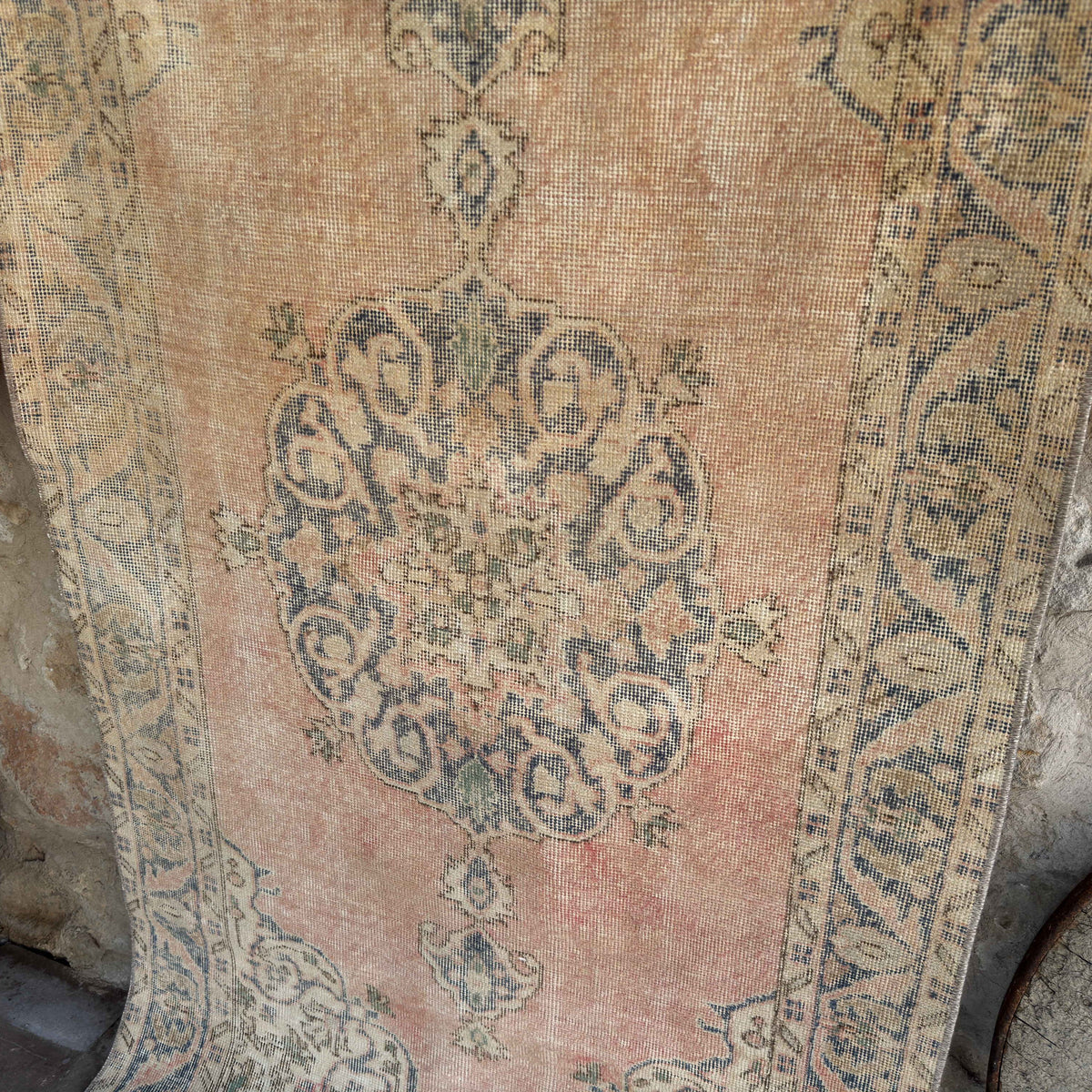 Pink 4' x 7' vintage Turkish distressed rug in wool and cotton, shown on the floor.