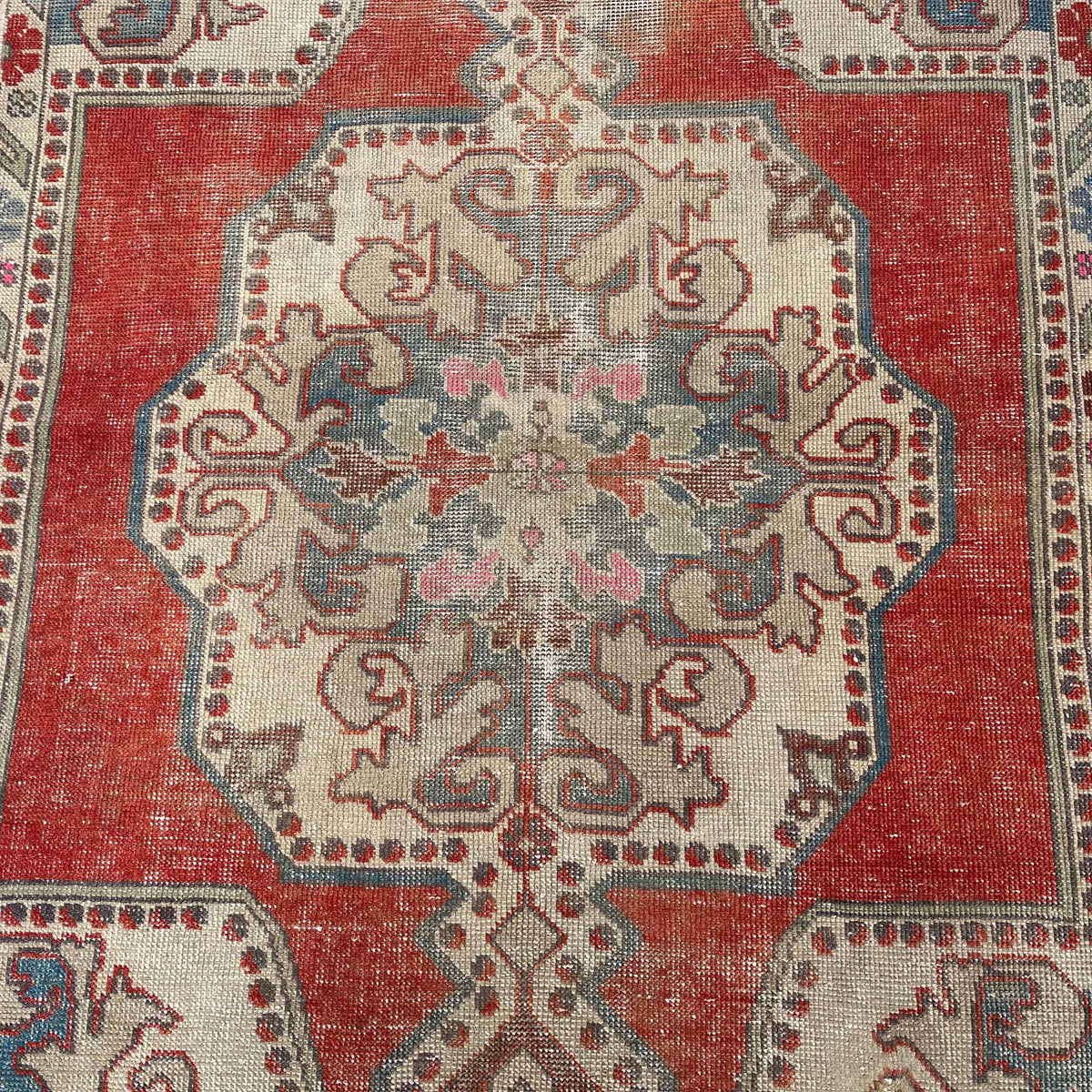 1970s red vintage Turkish distressed rug with geometric design, hand-knotted weave and low pile.