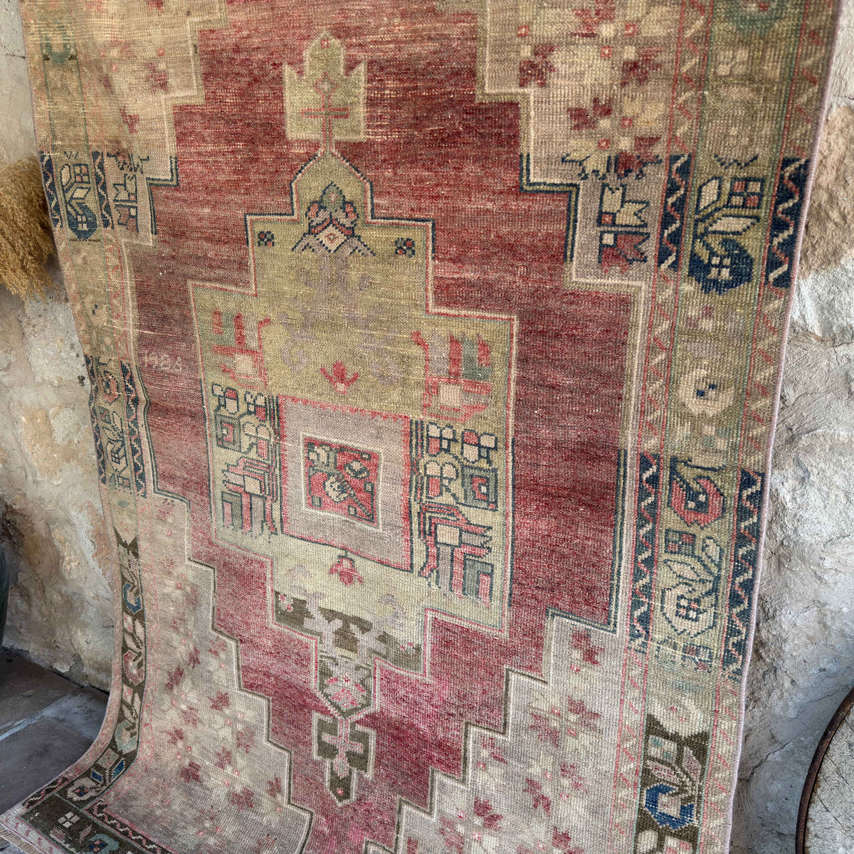 1970s red vintage Turkish distressed rug with traditional design, hand-knotted weave and low pile.