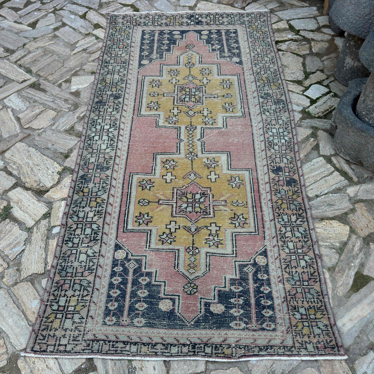 Pink 4' x 9' vintage Turkish distressed rug in wool and cotton, shown on the floor.