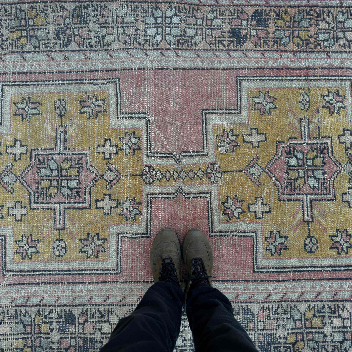 1970s pink vintage Turkish distressed rug with traditional design, hand-knotted weave and low pile.
