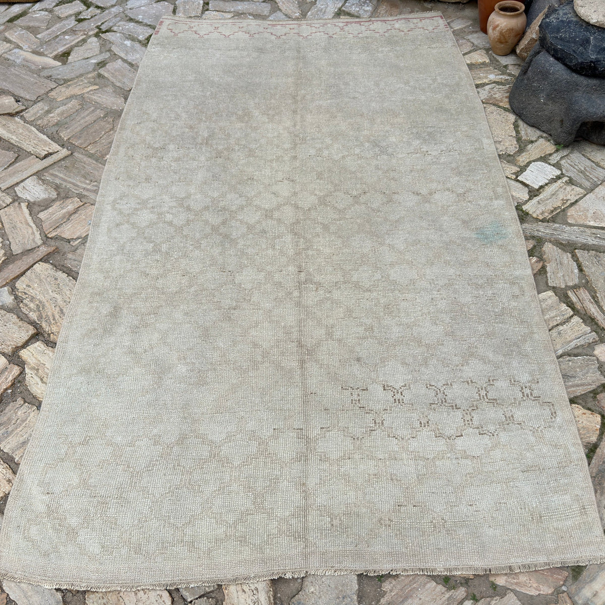 Beige 5' x 9' vintage Turkish distressed rug in wool and cotton, shown on the floor.