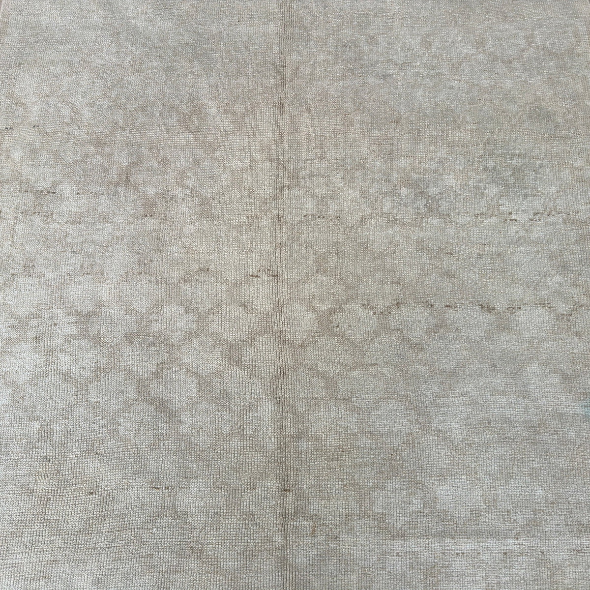 1970s beige vintage Turkish distressed rug with geometric design, hand-knotted weave and low pile.