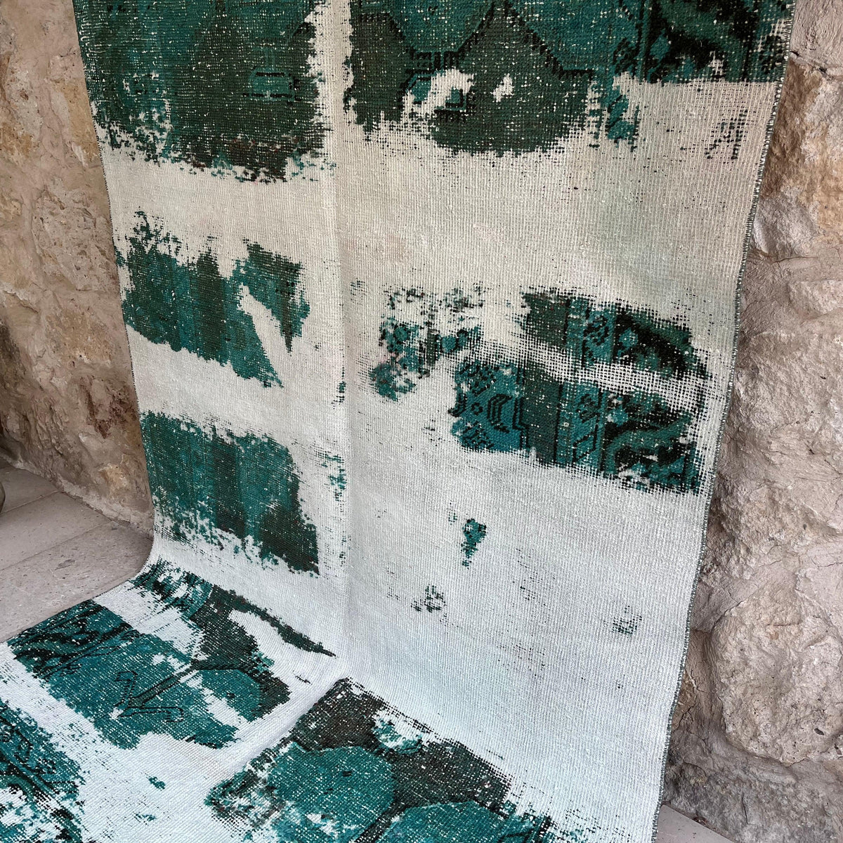 Green 5' x 9' vintage Turkish distressed rug in wool and cotton, shown on the floor.