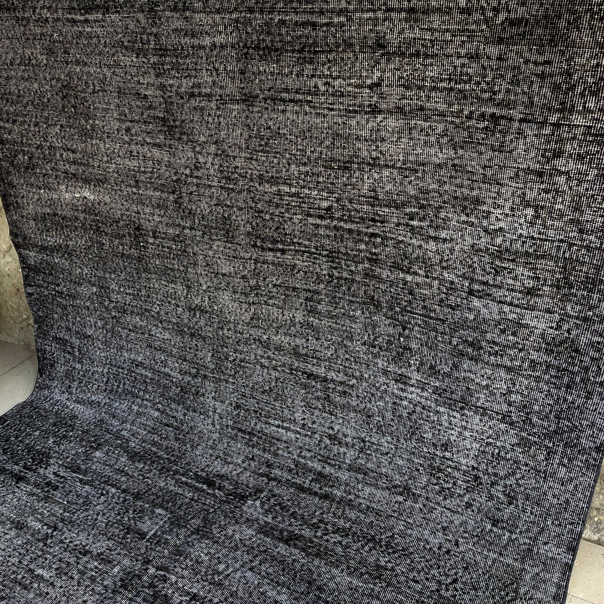 Black 6' x 9' vintage Turkish distressed rug in wool and cotton, shown on the floor.