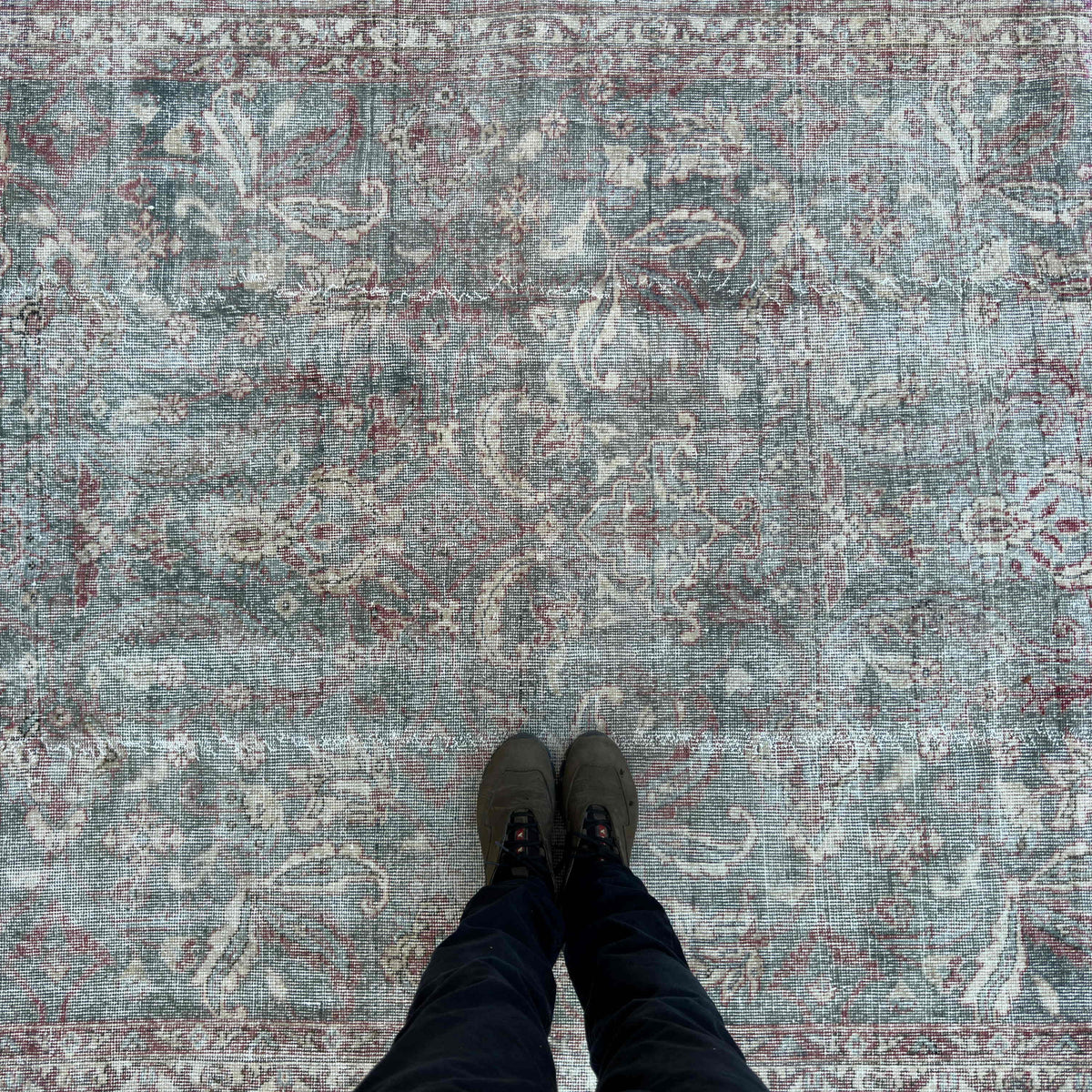 1970s pale green vintage Turkish distressed rug with traditional design, hand-knotted weave and low pile.