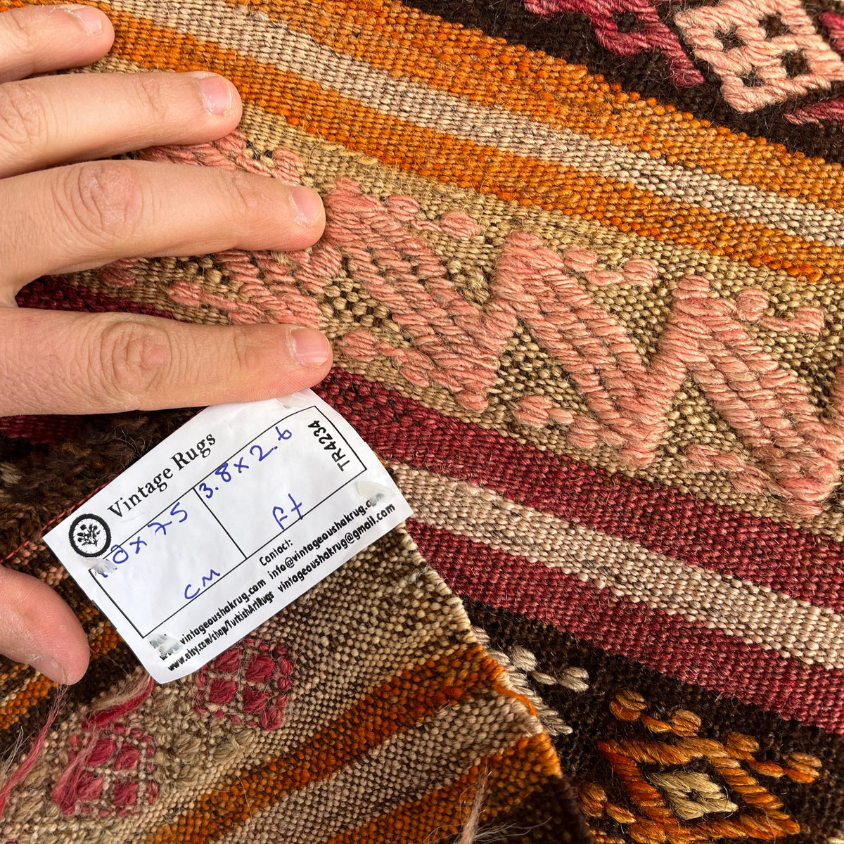 Orange 2' x 4' vintage Turkish flatweave rug in wool and cotton, shown on the floor.