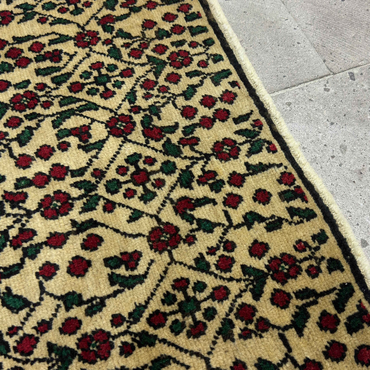 Close-up of the red vintage Turkish floral rug showing floral details, hand-knotted weave, wool and cotton and low pile.