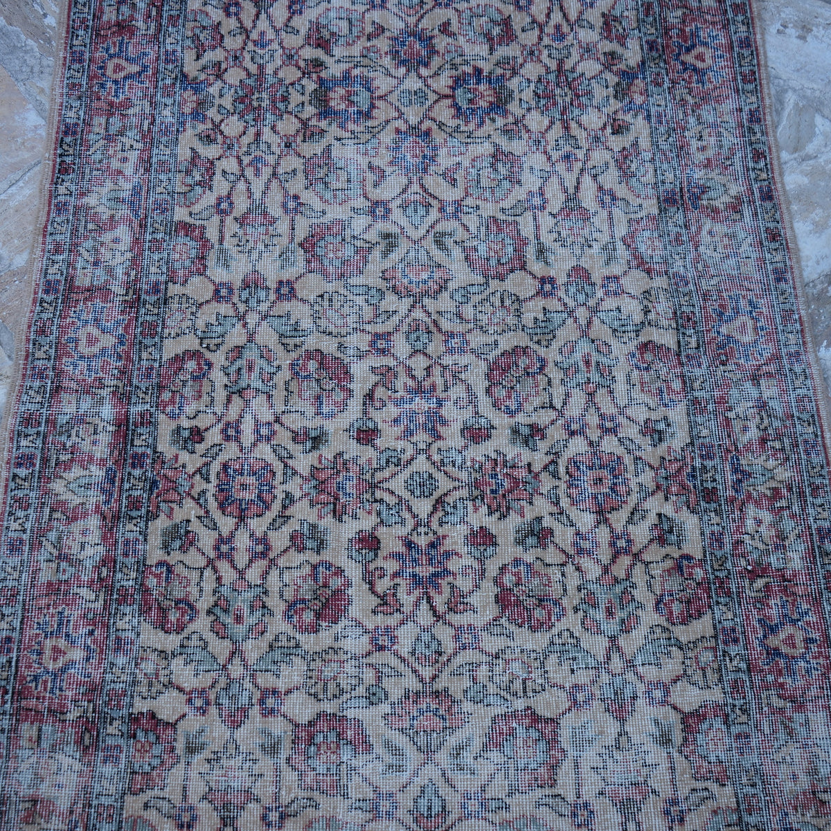 Close-up of the red vintage Turkish floral rug showing floral details, hand-knotted weave, wool and cotton and low pile.