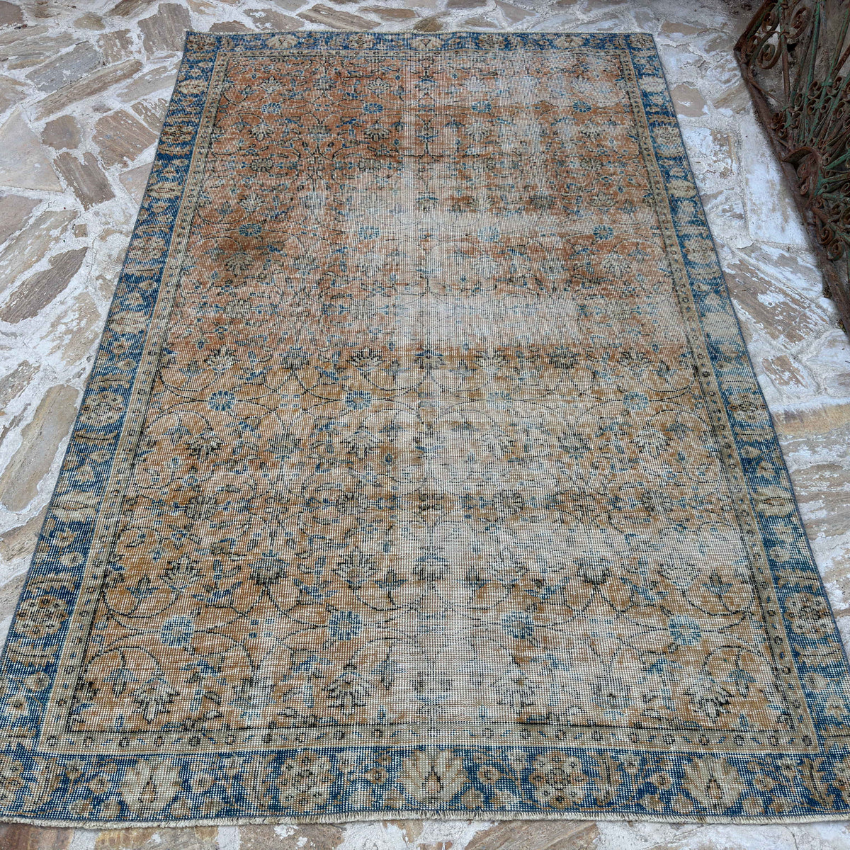 Orange 5' x 8' vintage Turkish floral rug in wool and cotton, shown on the floor.