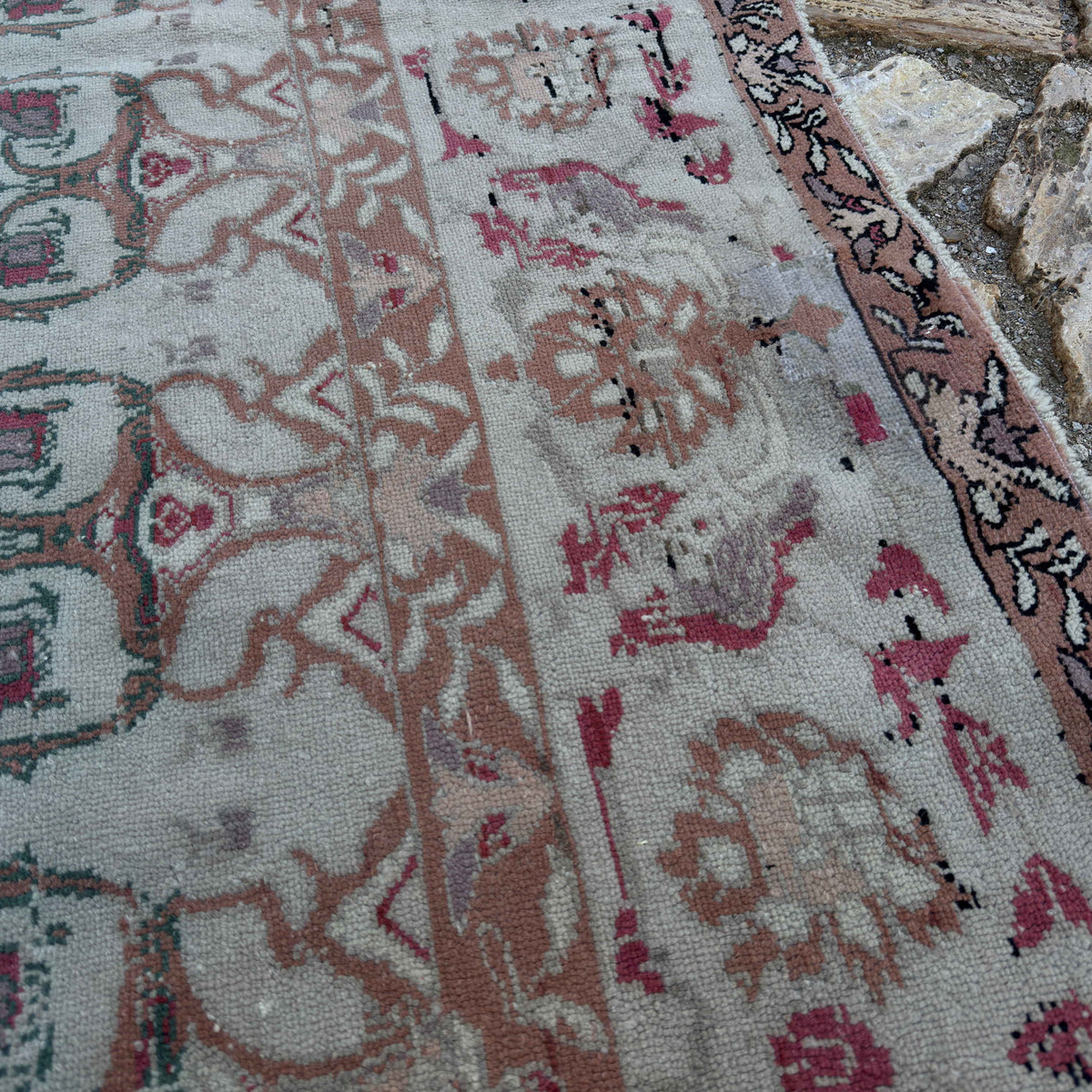 Close-up of the gray vintage Turkish floral rug showing floral details, hand-knotted weave, wool and cotton and low pile.