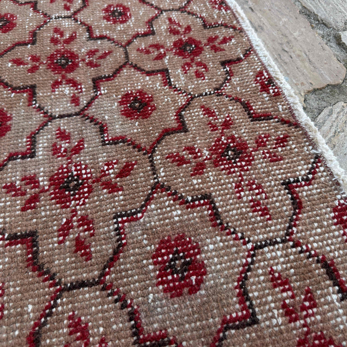 Close-up of the red vintage Turkish geometric rug showing geometric details, hand-knotted weave, wool and cotton and low pile.