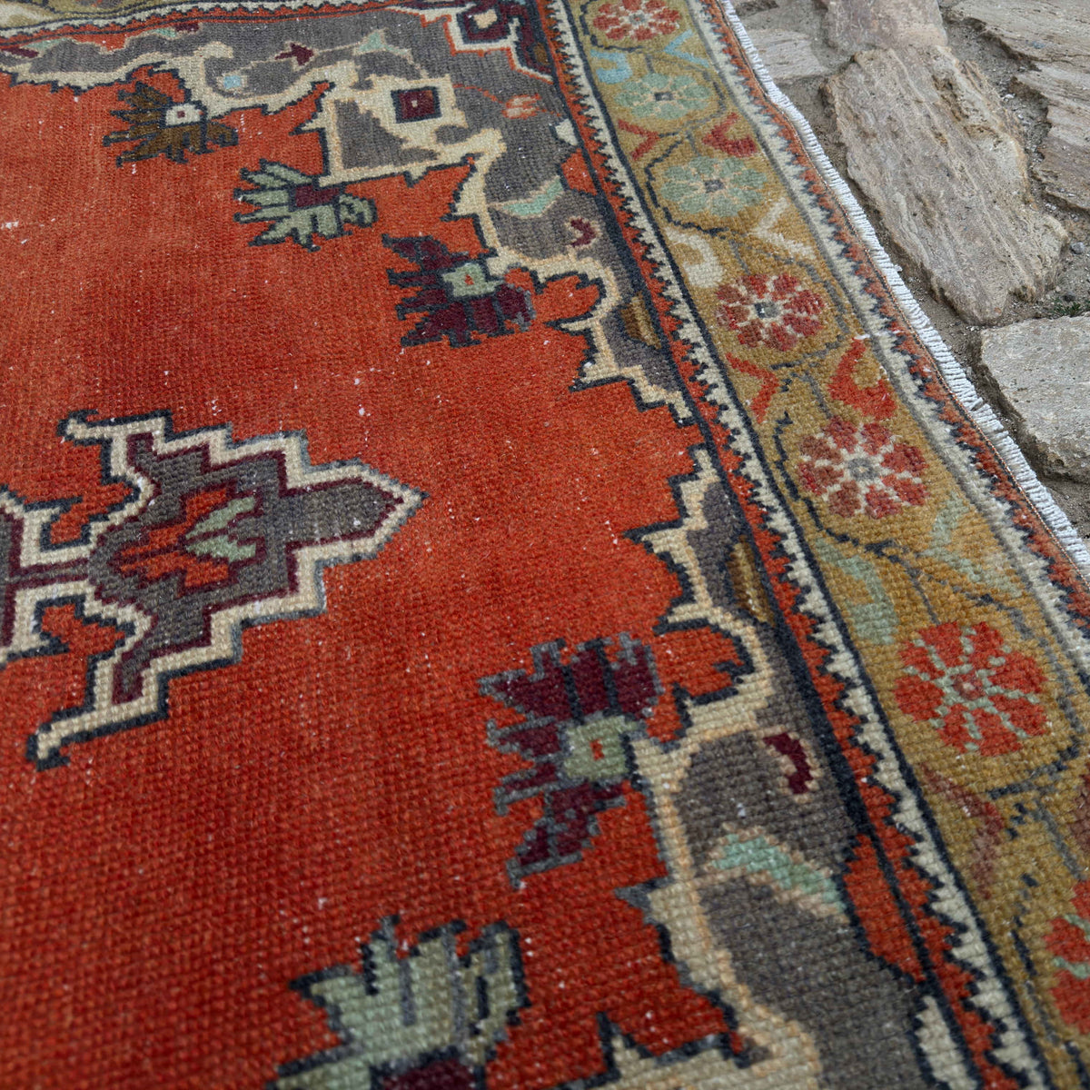 Close-up of the orange vintage Turkish geometric rug showing traditional details, hand-knotted weave, wool and cotton and low pile.