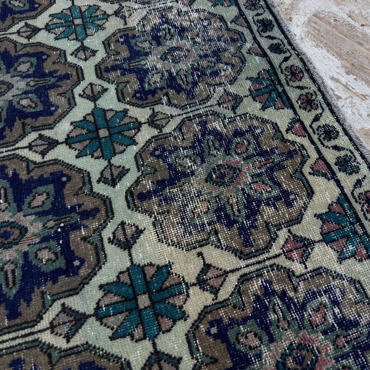 Close-up of the blue vintage Turkish geometric rug showing geometric details, hand-knotted weave, wool and cotton and low pile.