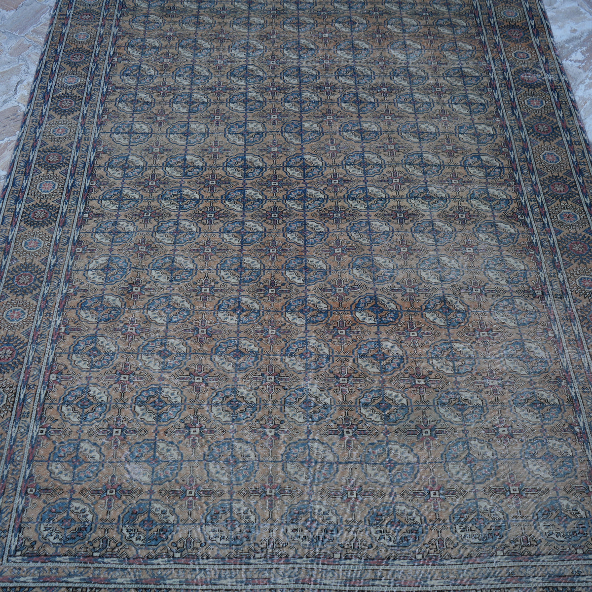 Close-up of the pale orange vintage Turkish geometric rug showing geometric details, hand-knotted weave, wool and cotton and low pile.