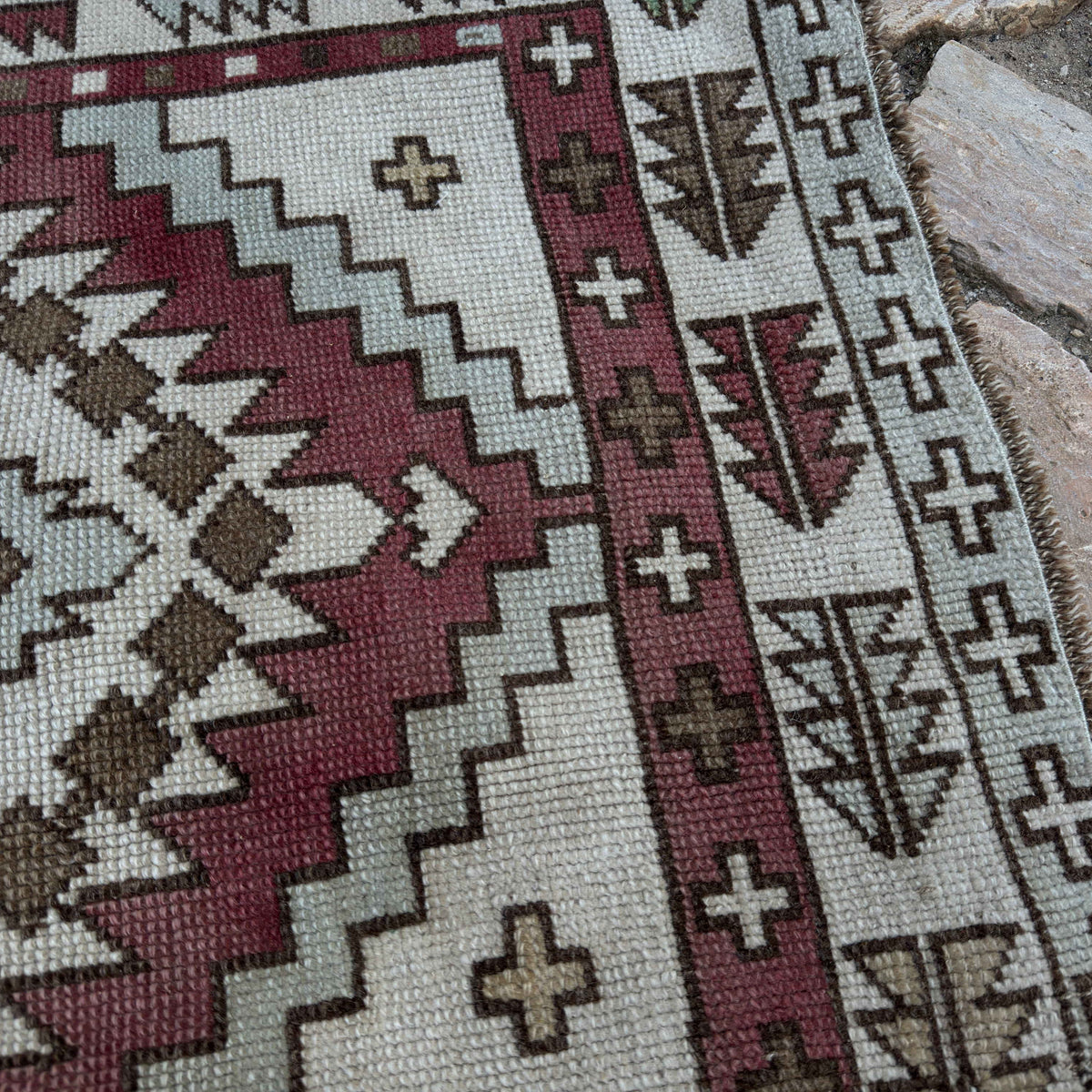 Close-up of the red vintage Turkish geometric runner rug showing neutral details, hand-knotted weave, wool and cotton and low pile.